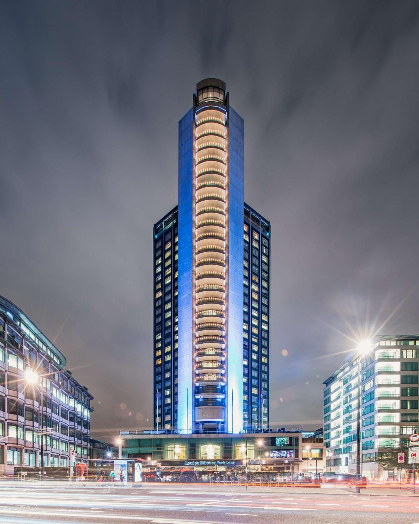 a tall building with blue lights in a city at London Hilton on Park Lane in London
