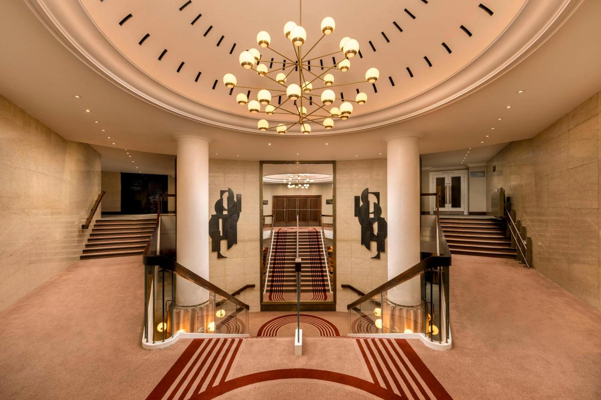 a large lobby with a large clock on the wall at London Hilton on Park Lane in London
