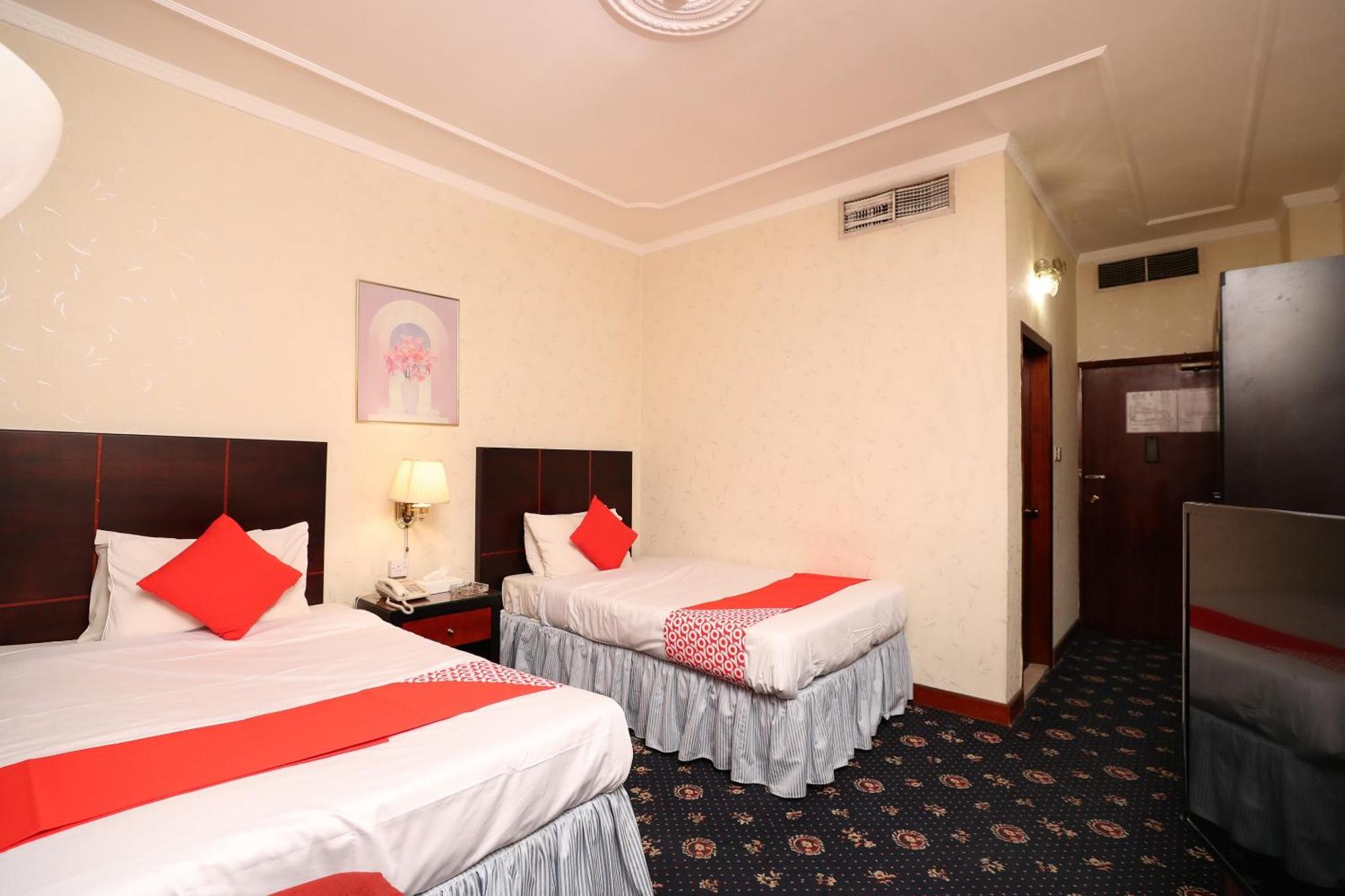 a hotel room with two beds with red pillows at OYO 112 Semiramis Hotel in Manama +39 photos
