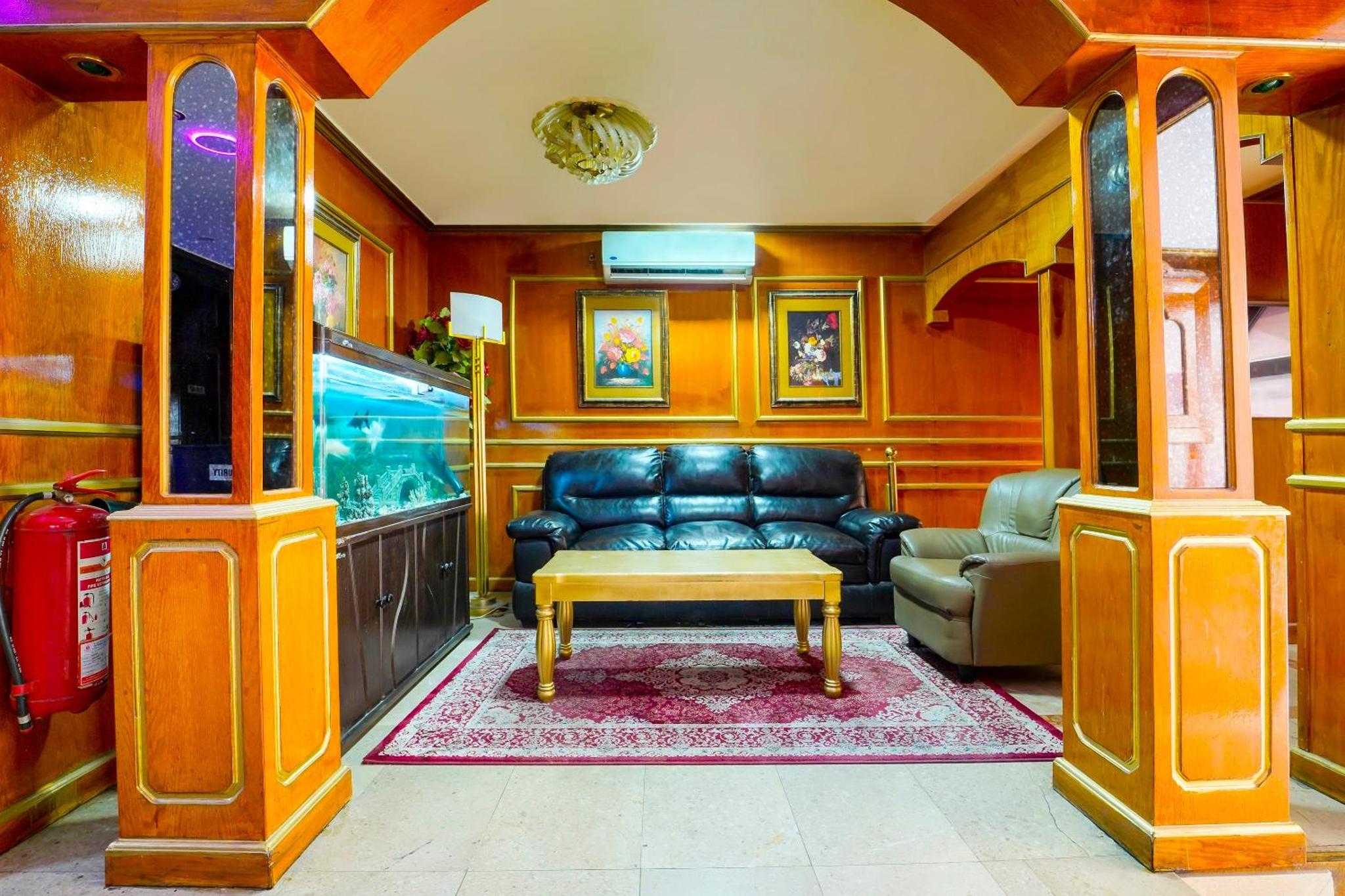 a living room with a couch and a fish tank at OYO 124 Al Salam Palace Hotel in Manama