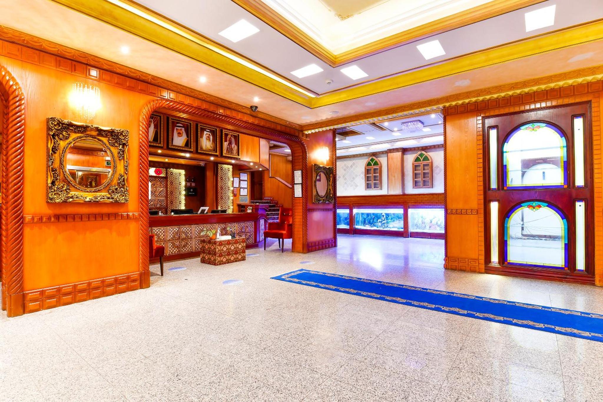 a large room with orange walls and a lobby at Capital O 125 Moon Plaza Hotel in Manama