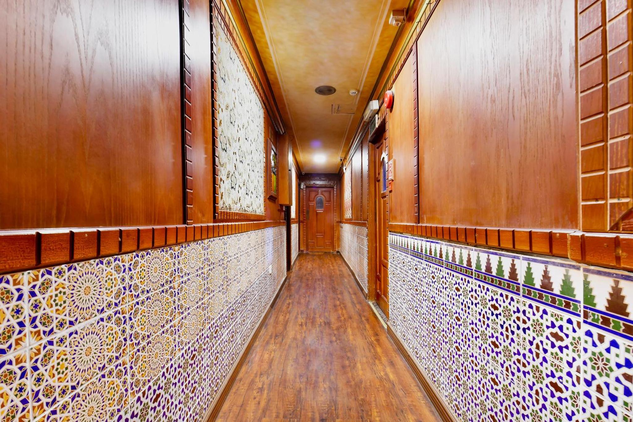 a corridor of a wine cellar with wooden walls at Capital O 125 Moon Plaza Hotel in Manama