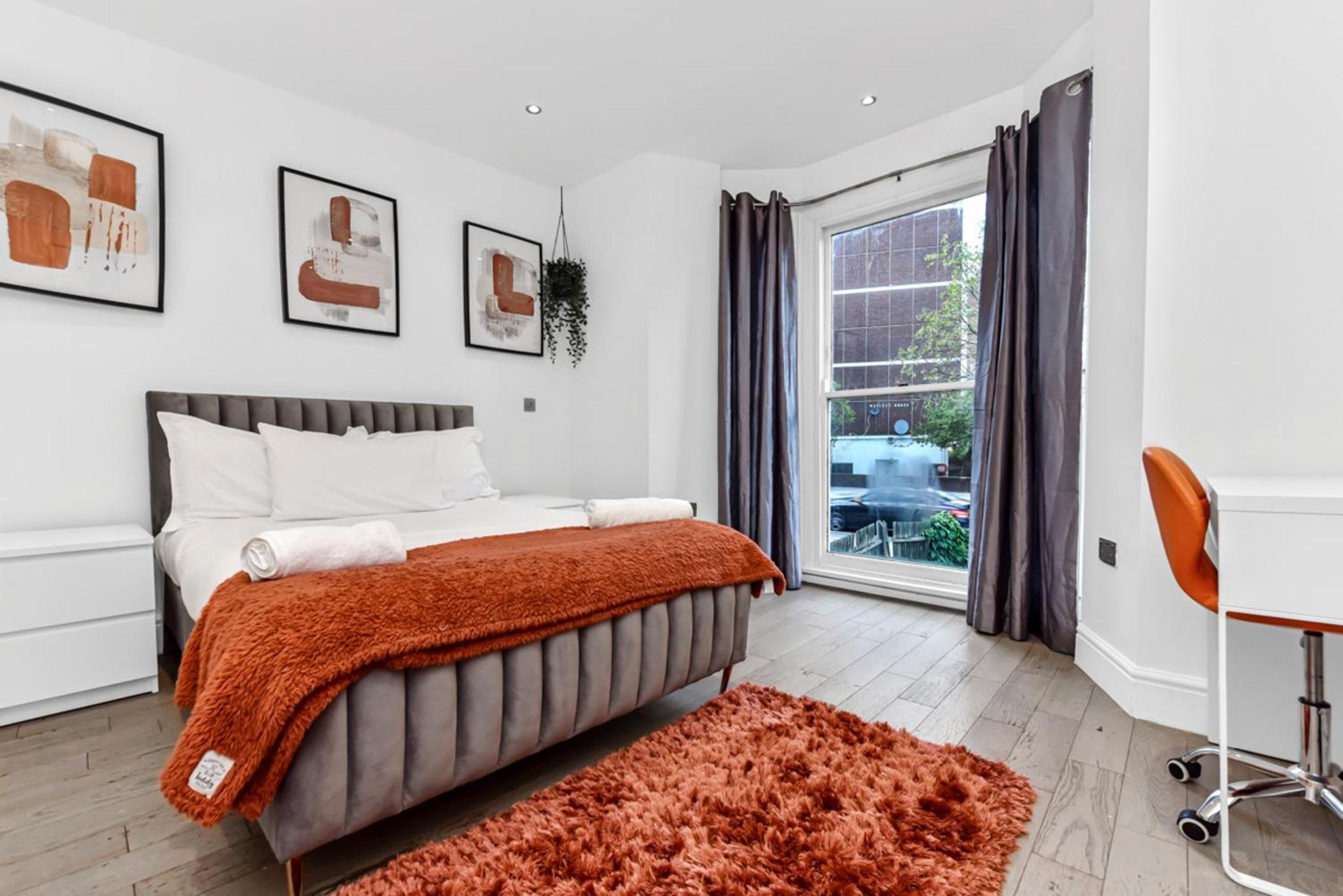 a bedroom with a bed with an orange blanket at Central, modern 1 Bed in Kennington, Sleeps 4 in London