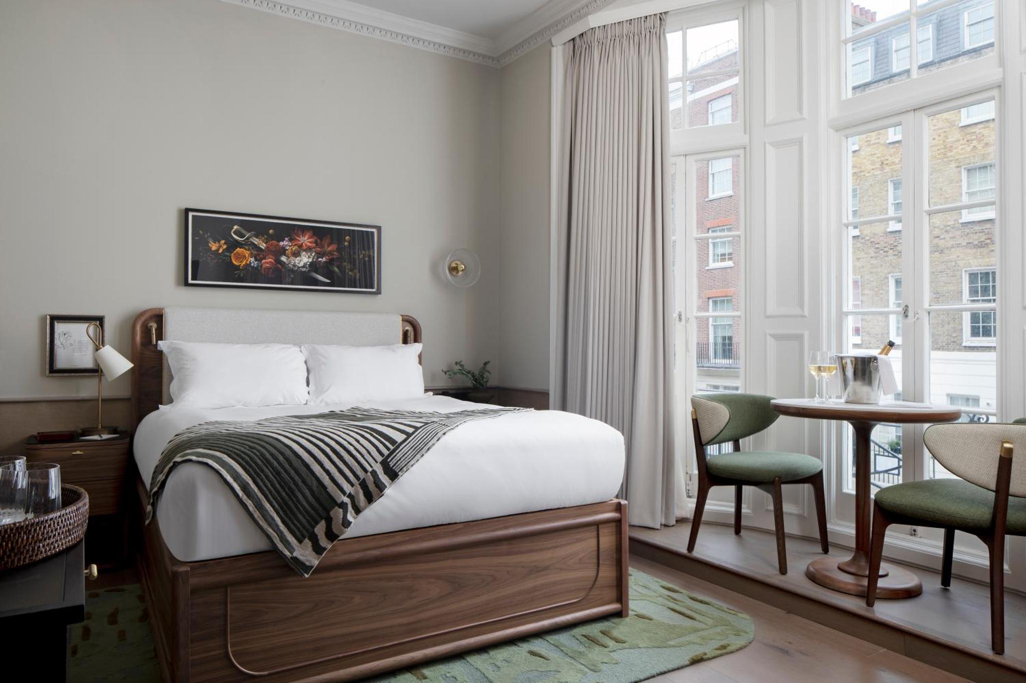 a bedroom with a bed and a table and a window at Montcalm Mayfair Townhouse in London