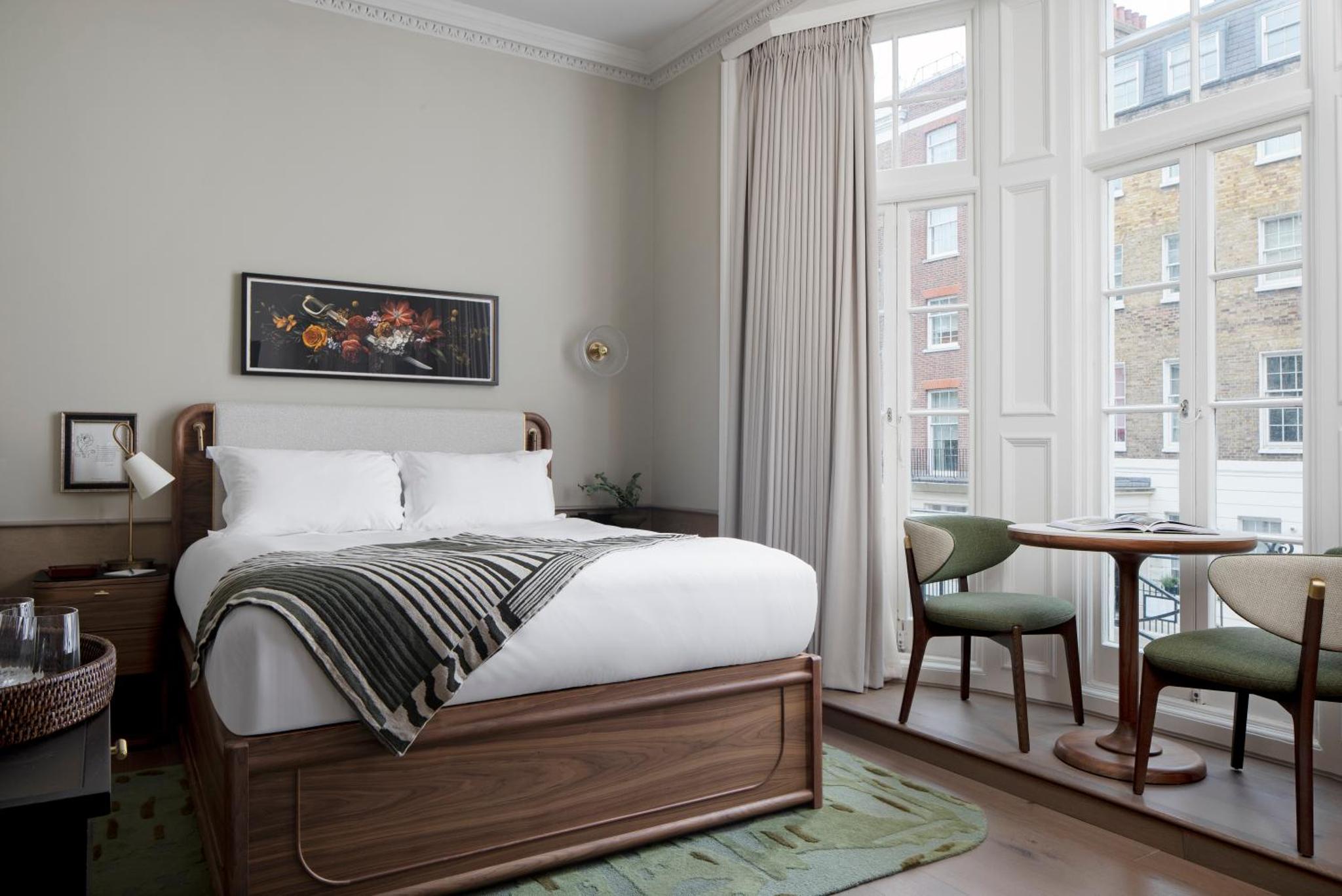 a bedroom with a bed and a table and a window at Montcalm Mayfair Townhouse in London