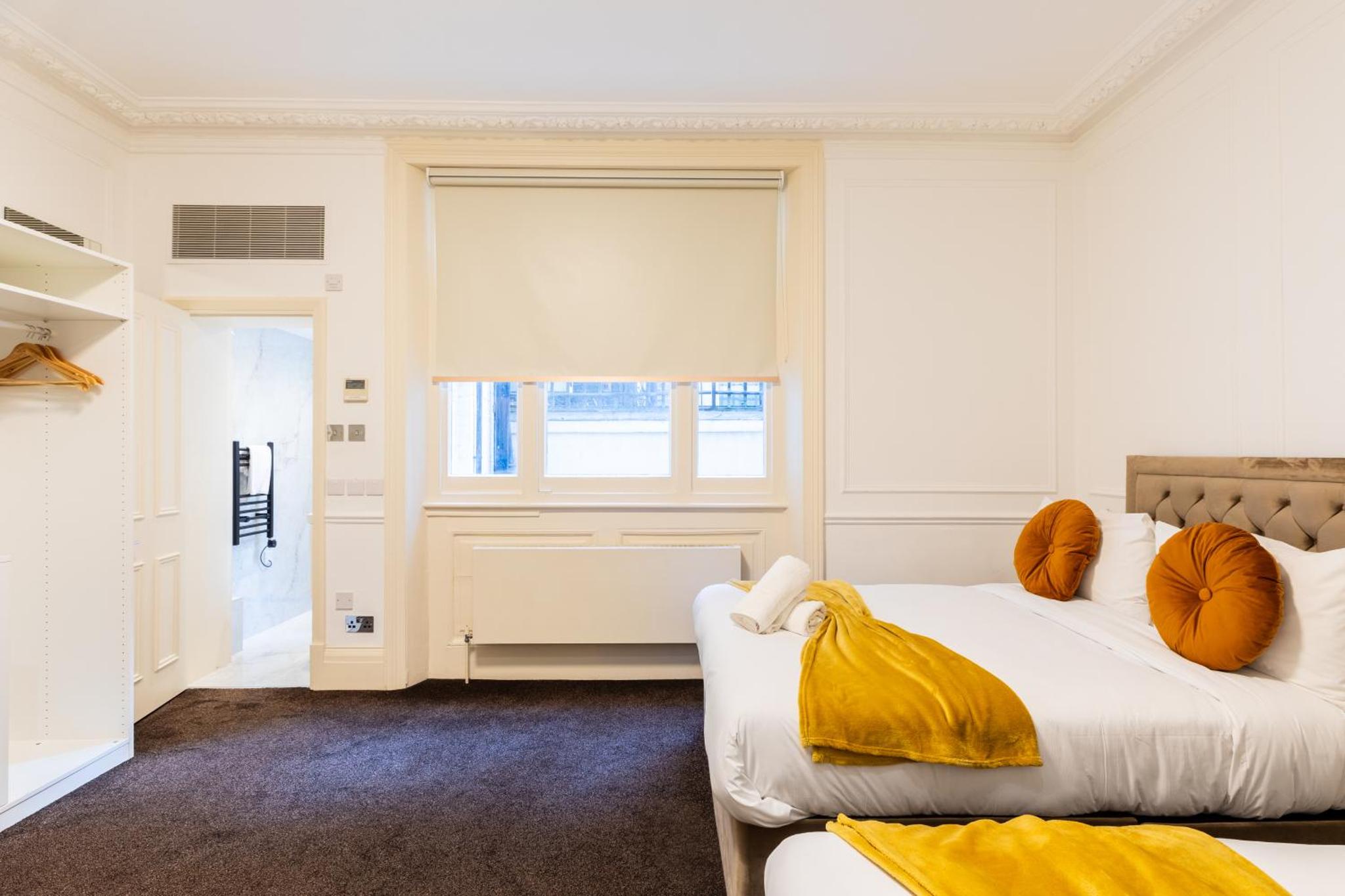 a bedroom with two beds and a window at Mayfair Residences in London +39 photos