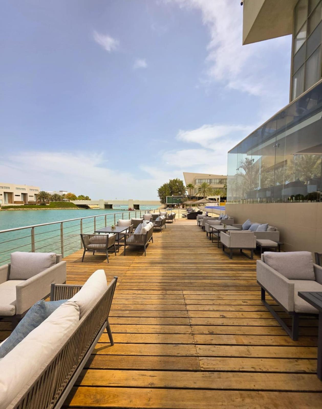 a deck with couches and chairs on a building at Dragon Beach Hotel in Manama