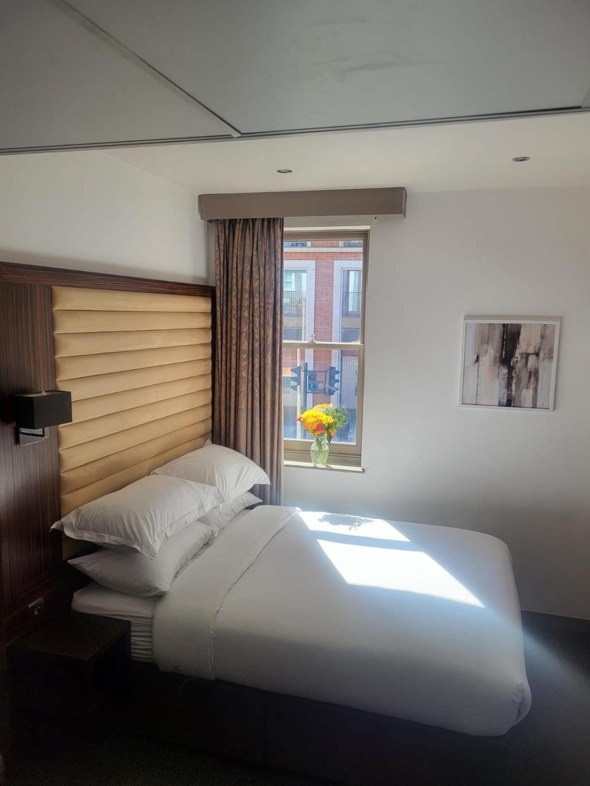 a large white bed in a room with a window at Central Boutique Room 302 in London