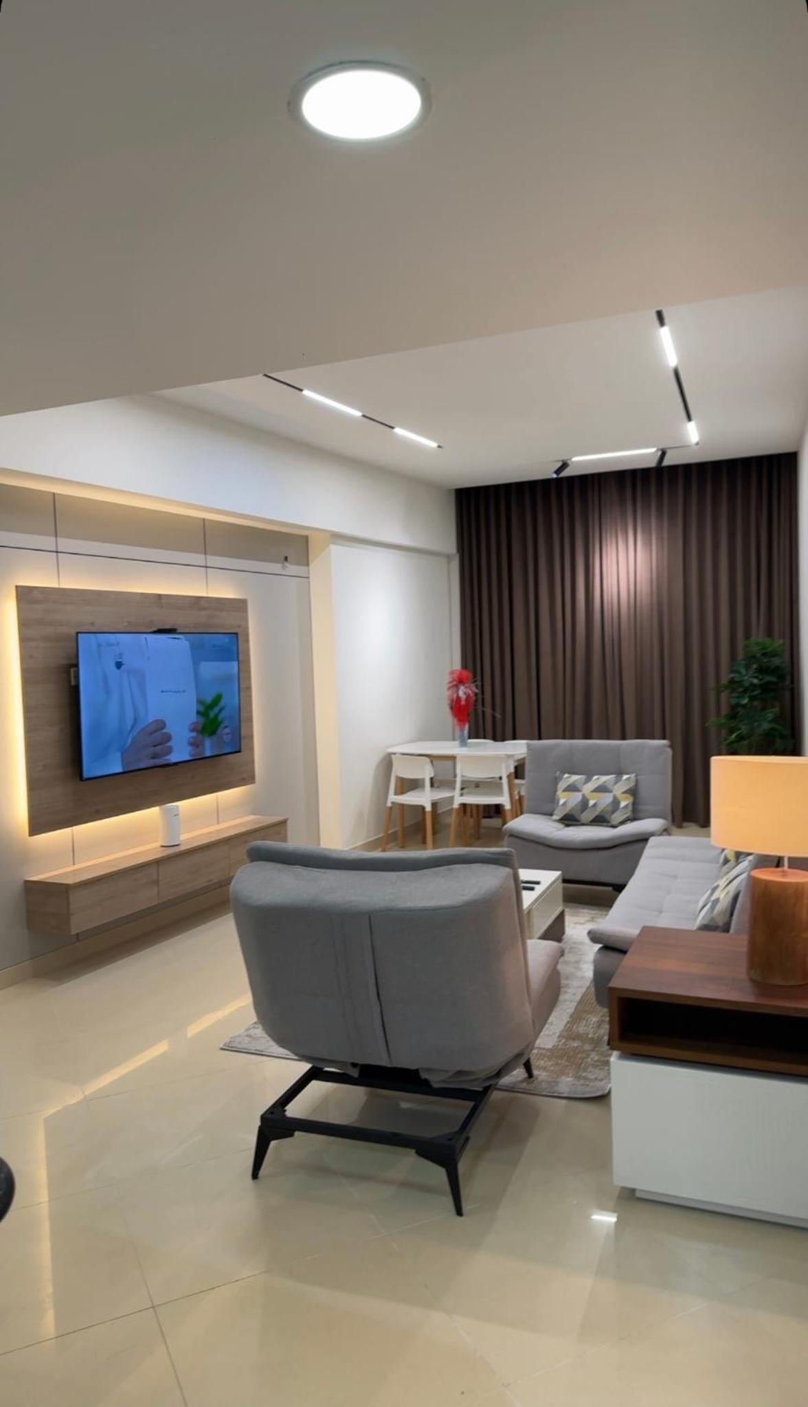 a living room with couches and a flat screen tv at شقة خاصة in Muharraq