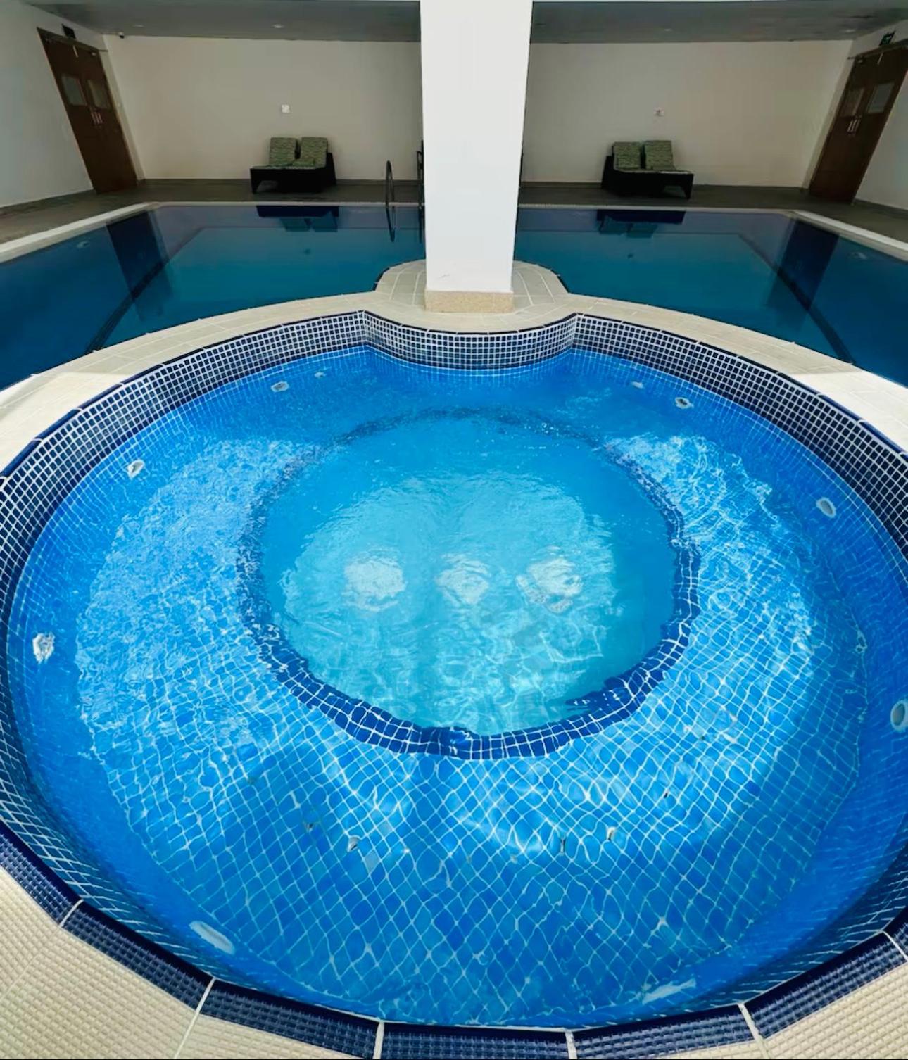 a large blue swimming pool in a building at شقة خاصة in Muharraq