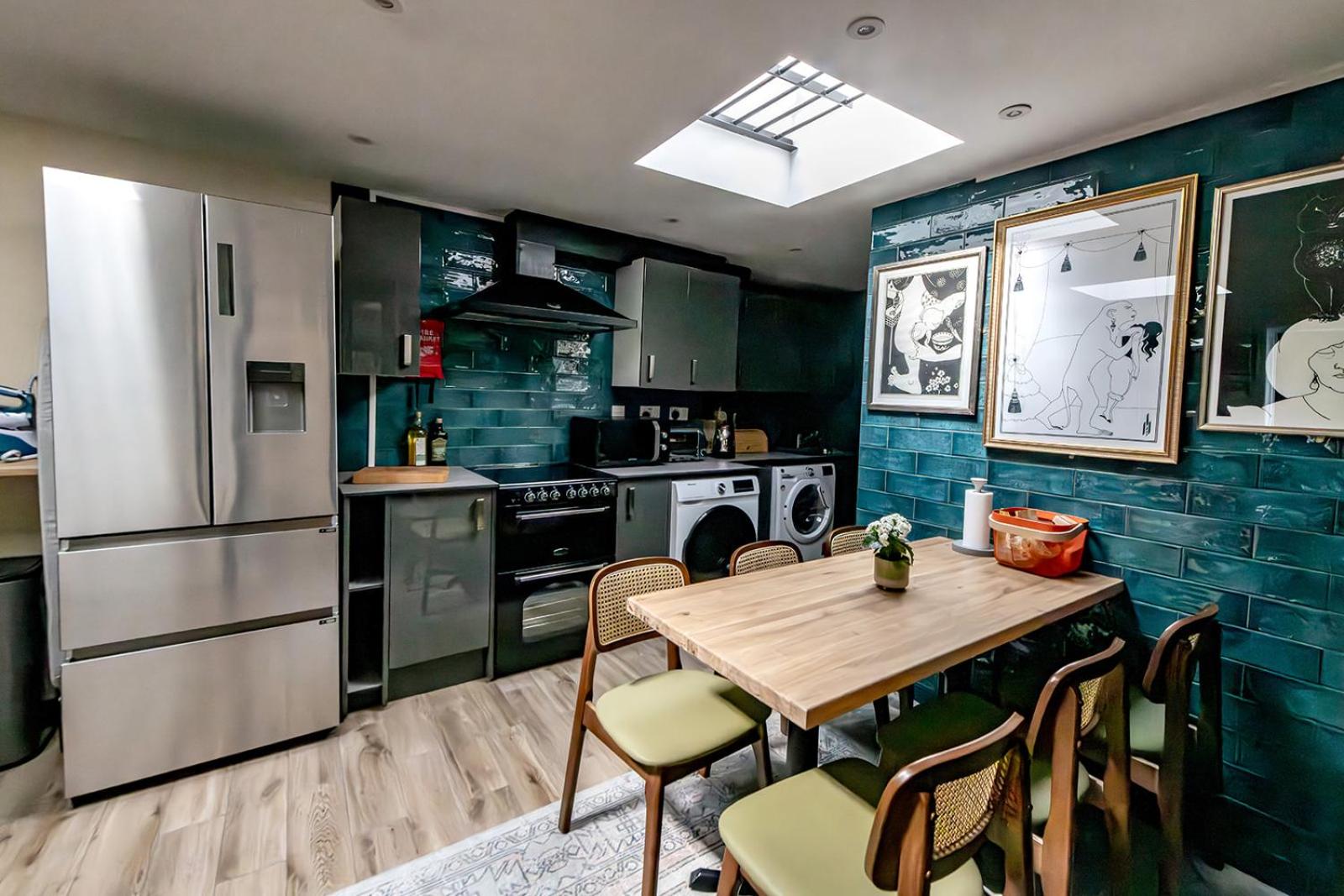 a kitchen with a table and a refrigerator at 82A Dalston Lane Terrace in London +41 photos