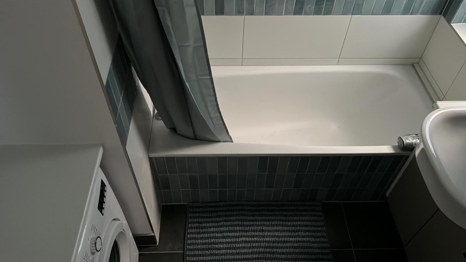 a small bathroom with a tub and a sink at Large, quiet flat in Islington in London +17 photos