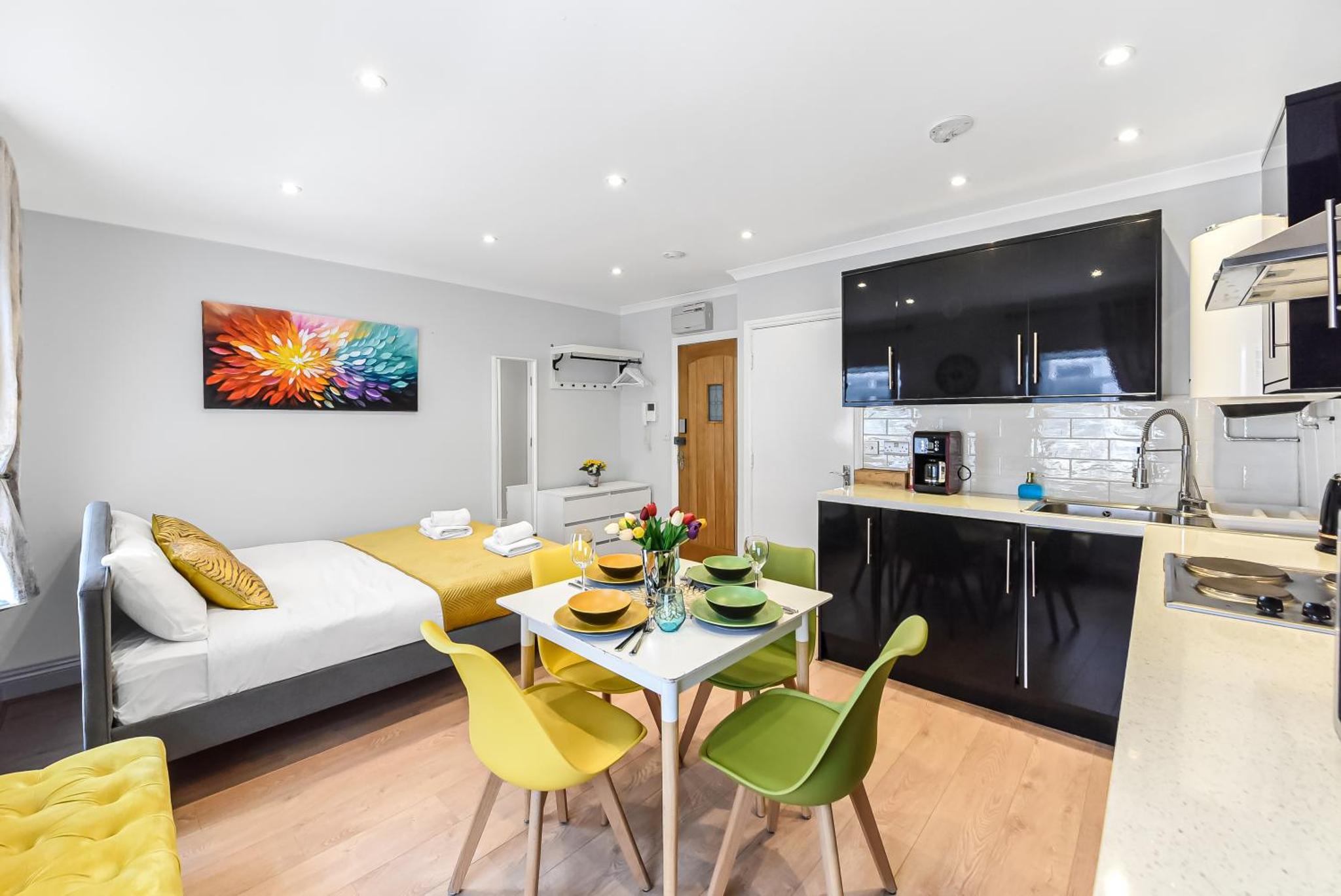 a kitchen and a living room with a table and chairs at Beautiful Flat On Oxford Street in London