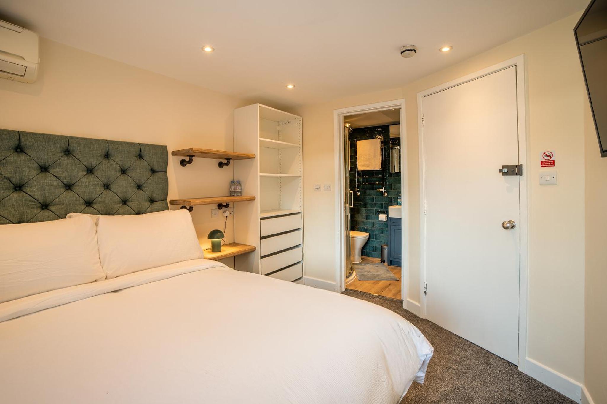 a bedroom with a white bed and a bathroom at 82A Dalston Lane Terrace in London