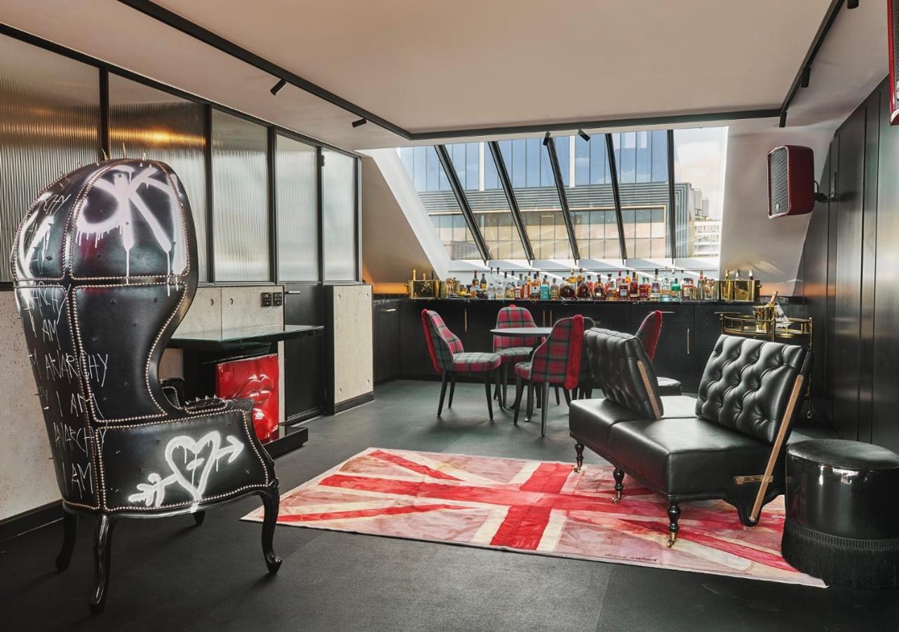 a room with chairs and a bar in the background at Chateau Denmark London in London