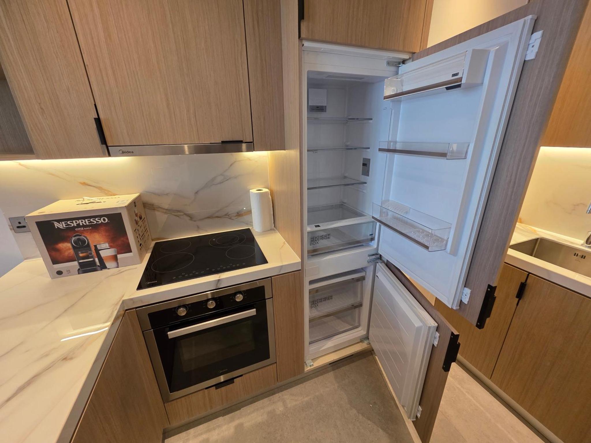 a kitchen with an open refrigerator with a stove at Elegant 1BR with Balcony PearlHouse Luxury Living! in Manama