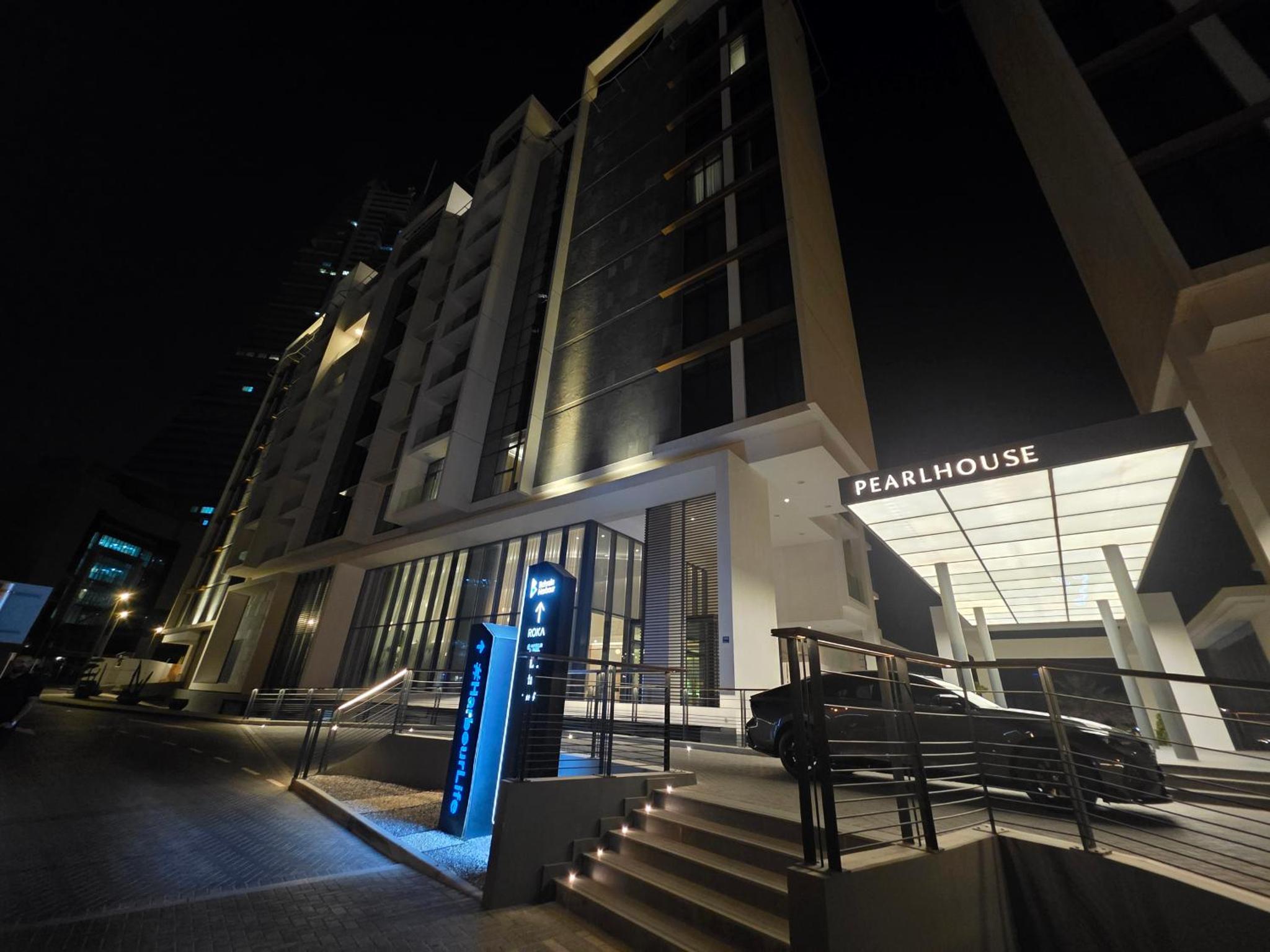 a car parked outside of a building at night at Elegant 1BR with Balcony PearlHouse Luxury Living! in Manama