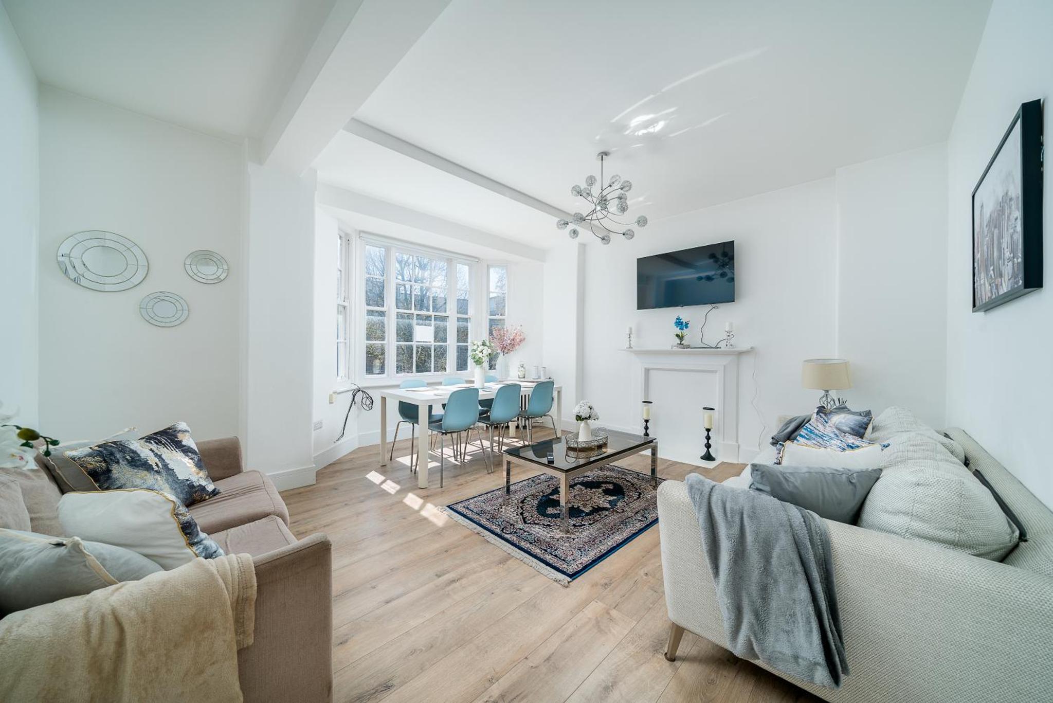 a living room with two couches and a table at Elegant 4 Bed Flat Opposite Hyde Park in London