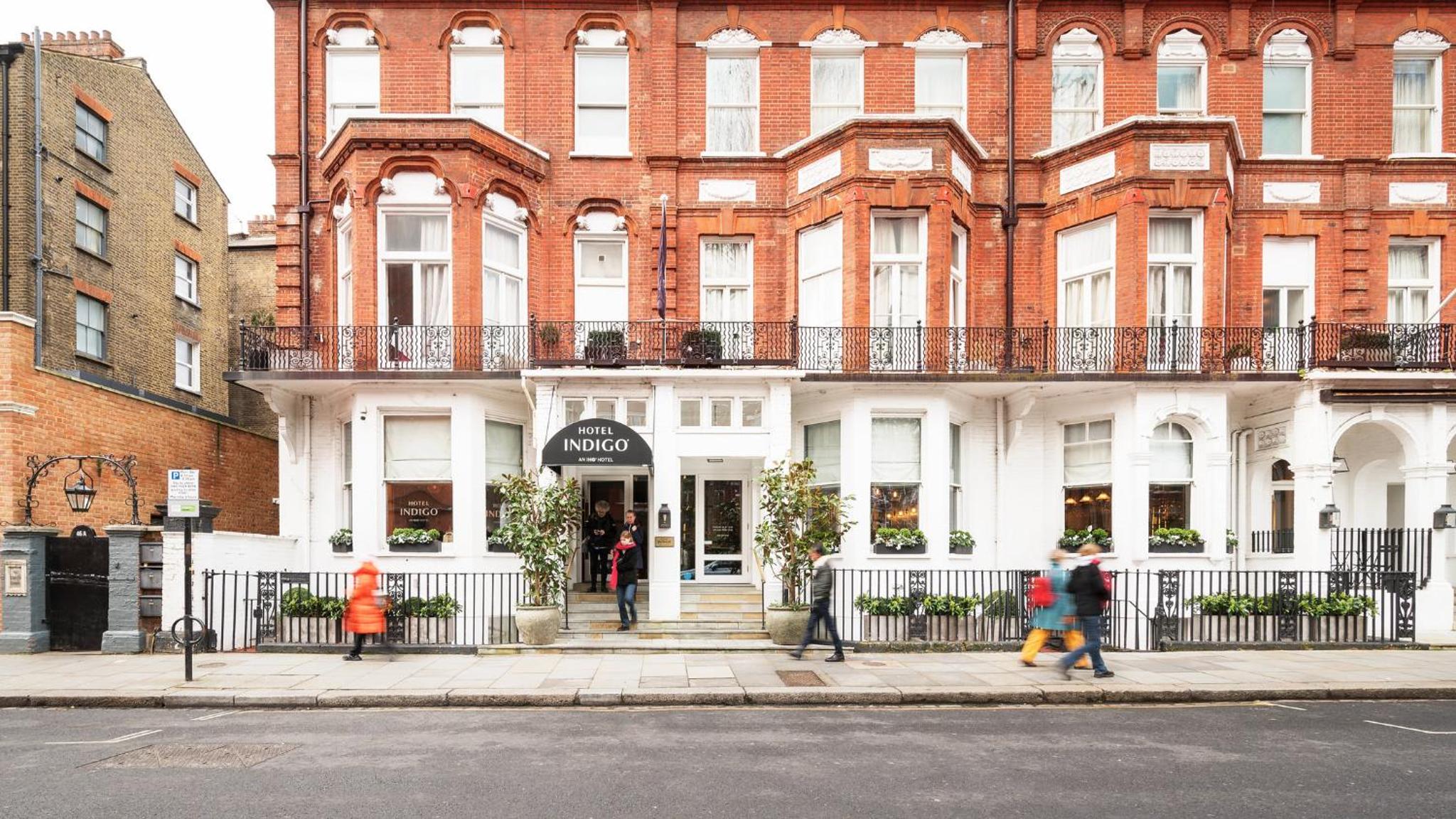 a building on a street with people walking in front of it at Hotel Indigo London - Kensington by IHG in London