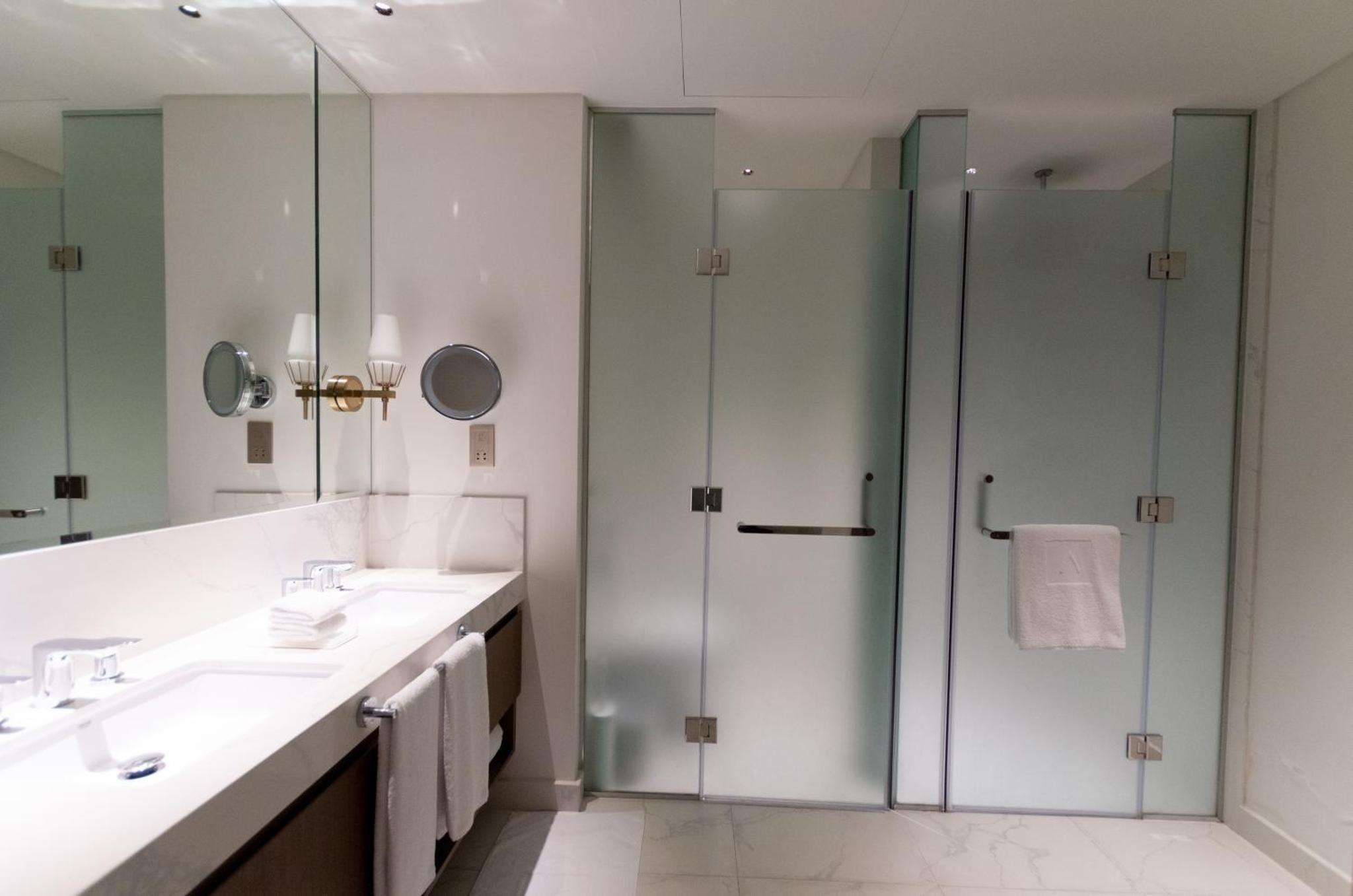 a bathroom with two sinks and a shower at Premium Apartments at Address Resort Residendtial Building in Muharraq +18 photos