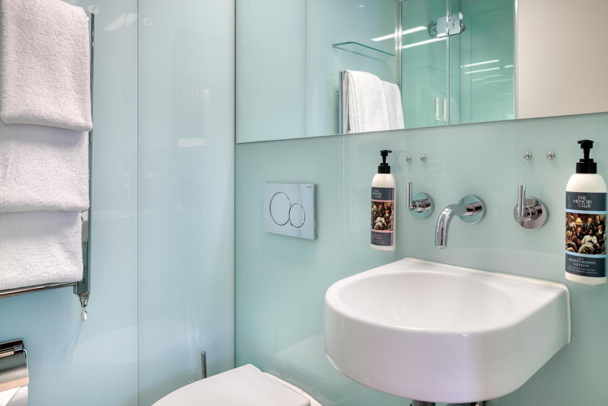 a bathroom with a white toilet and a sink at The Memoir Club, formerly Ambassadors Bloomsbury in London +28 photos