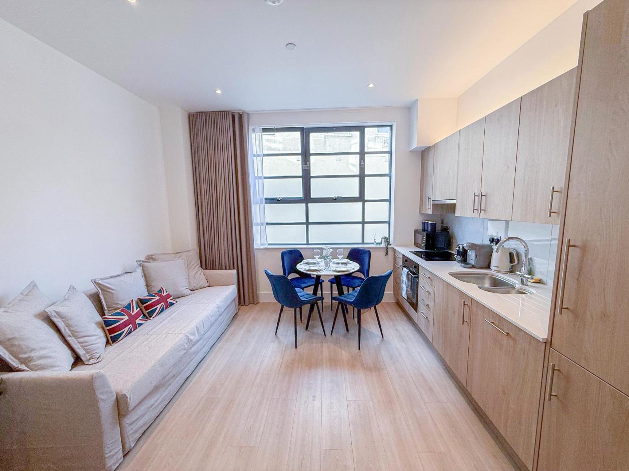 a living room with a couch and a table at 3-Bedroom with Balcony and Studio Apartments in St Johns Wood near Marylebone & Regents Park by NourNest Apartments in London