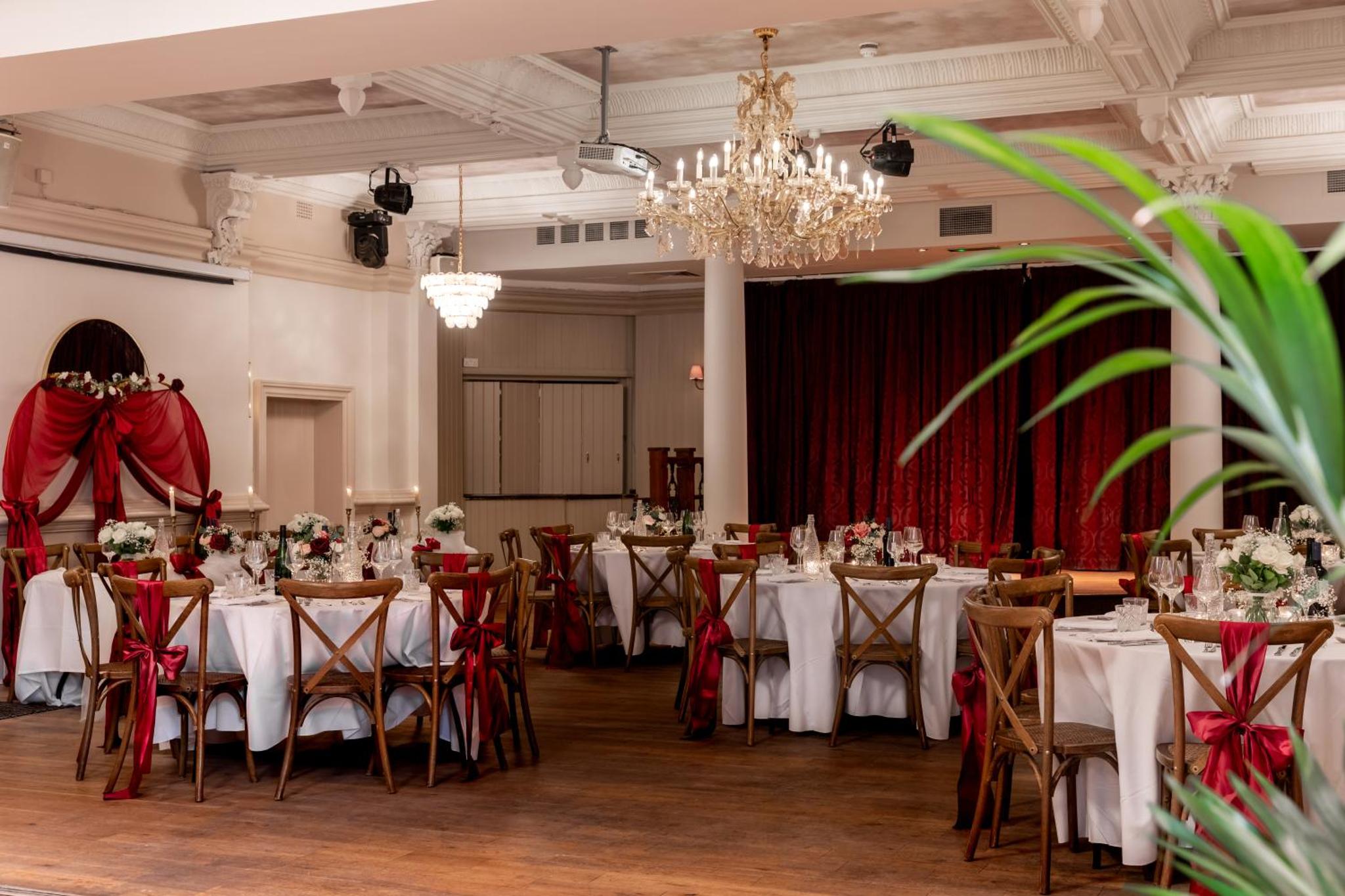 a dining room with tables and chairs with a chandelier at The Drayton Court Hotel in London