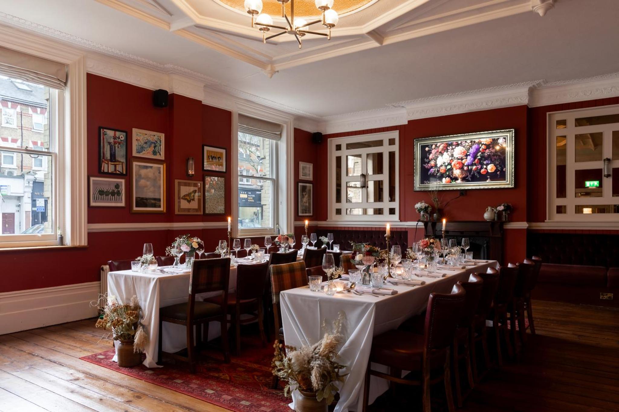 a dining room with white tables and chairs and red walls at The Drayton Court Hotel in London