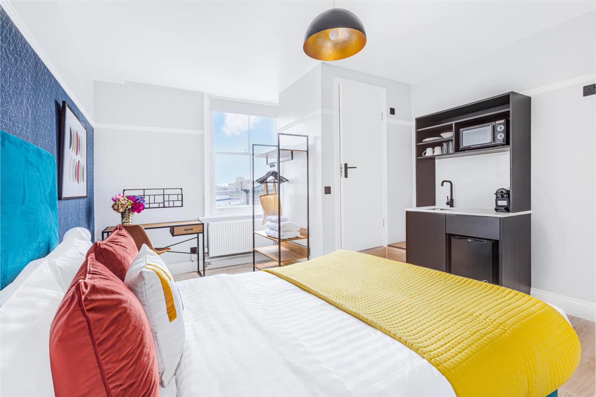 a bedroom with a bed with a yellow and white blanket at Bob W London Earl's Court - Philbeach Gardens in London +11 photos