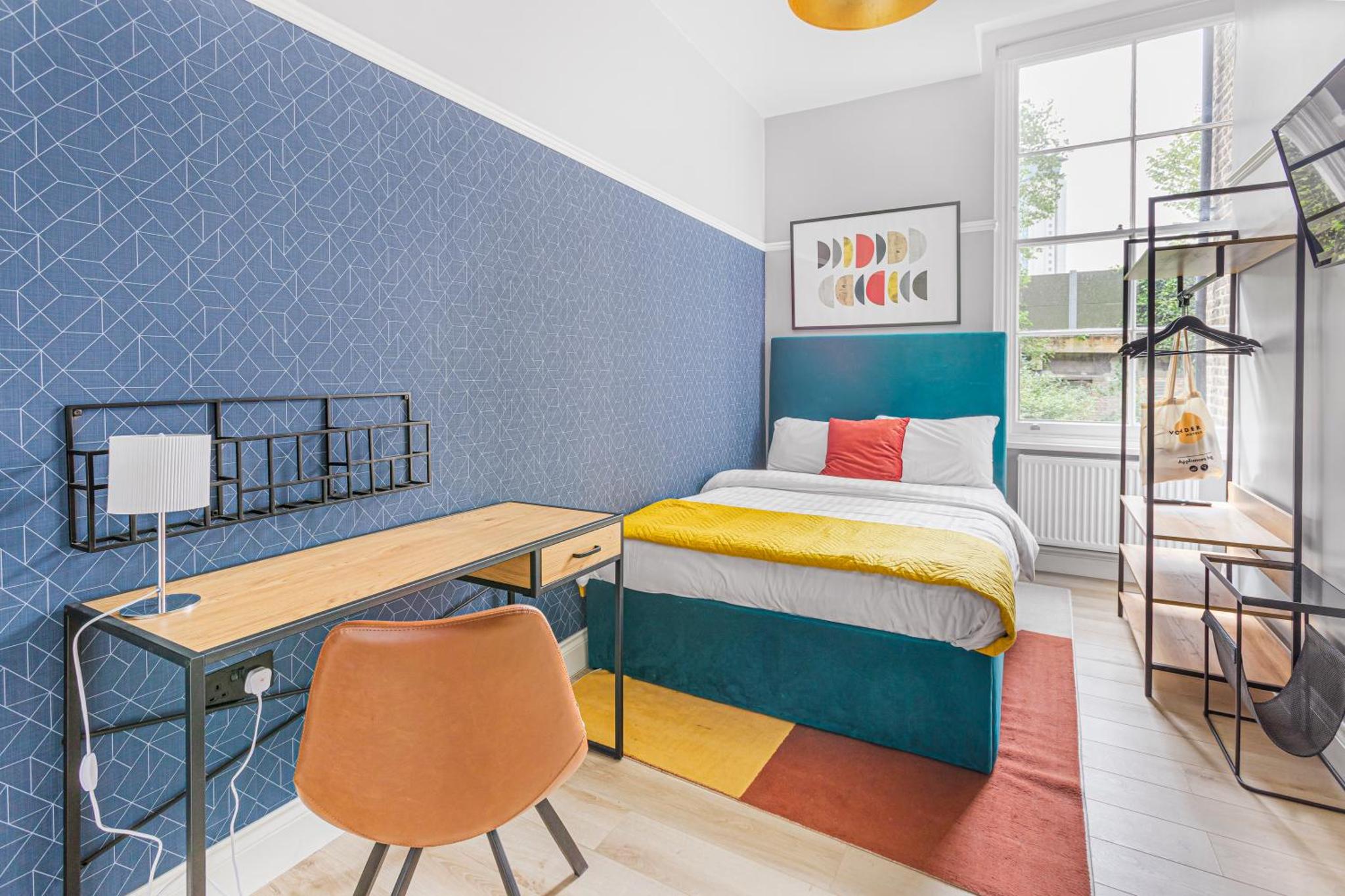 a bedroom with a bed and a desk and a ladder at Bob W London Earl's Court - Philbeach Gardens in London