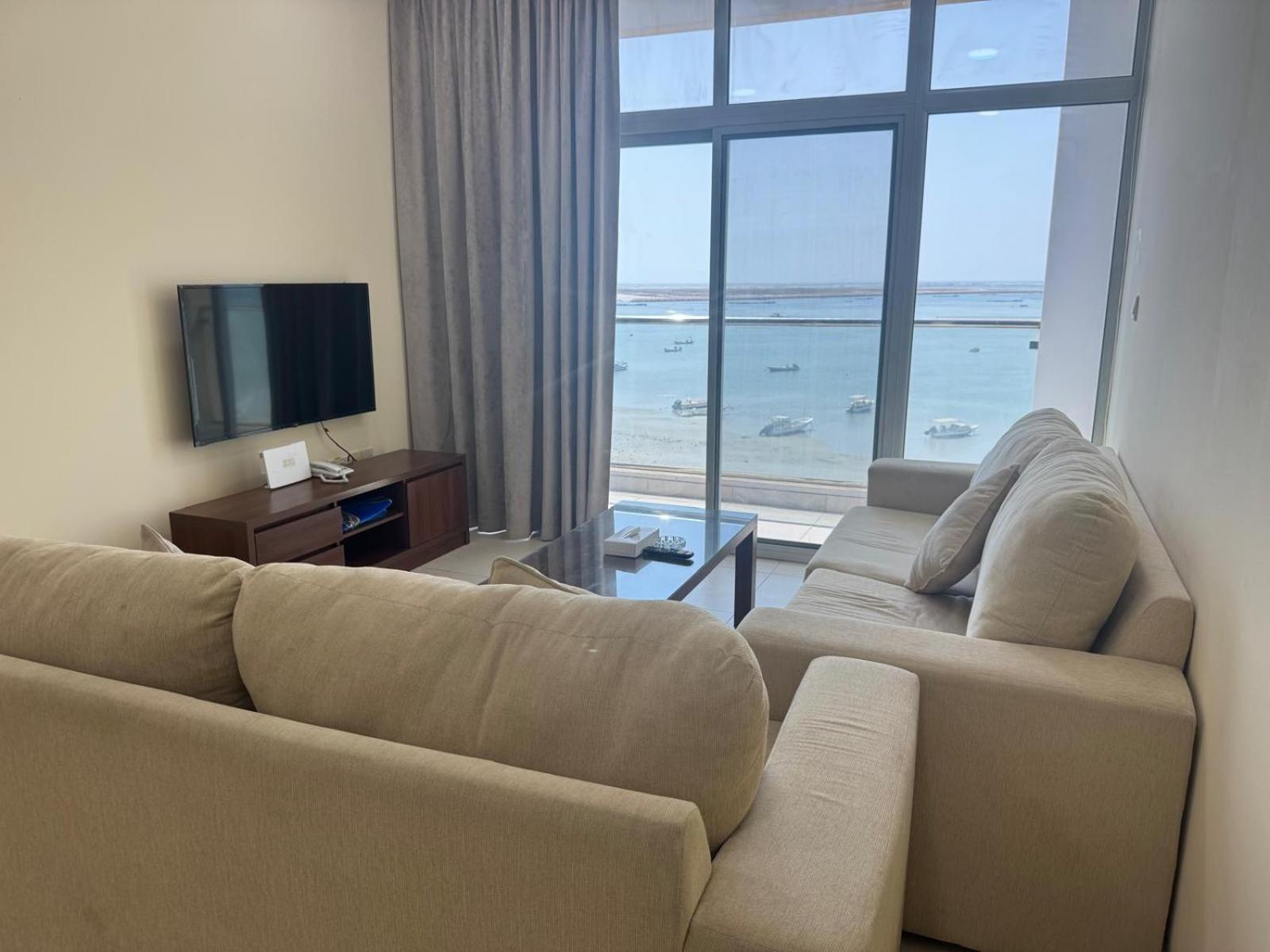 a living room with two couches and a view of the ocean at Marine Beach Apartment in Seef