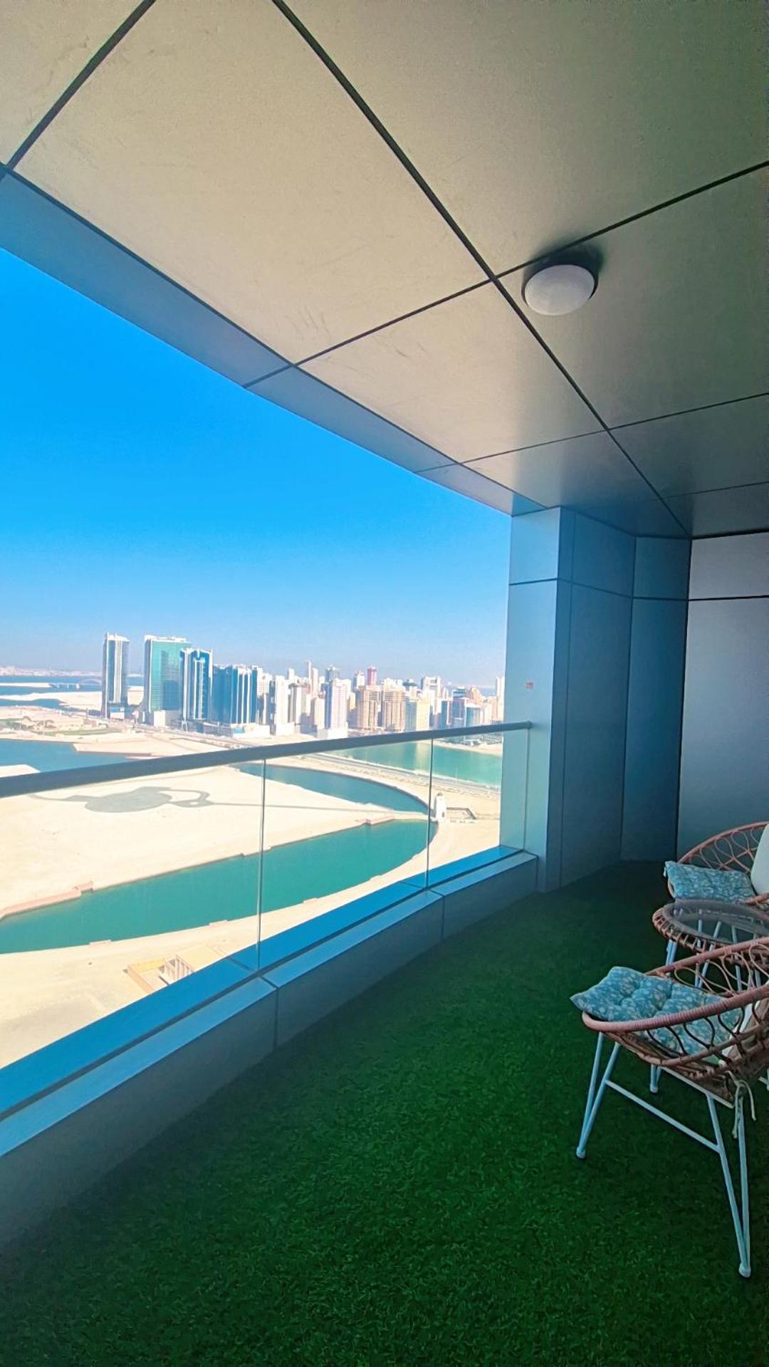 a room with a view of a beach and buildings at Luxury Romantic Sea View Apartment-ERAإقامة هادئة إطلالة بحرية موقع استثنائي- Manama in Manama