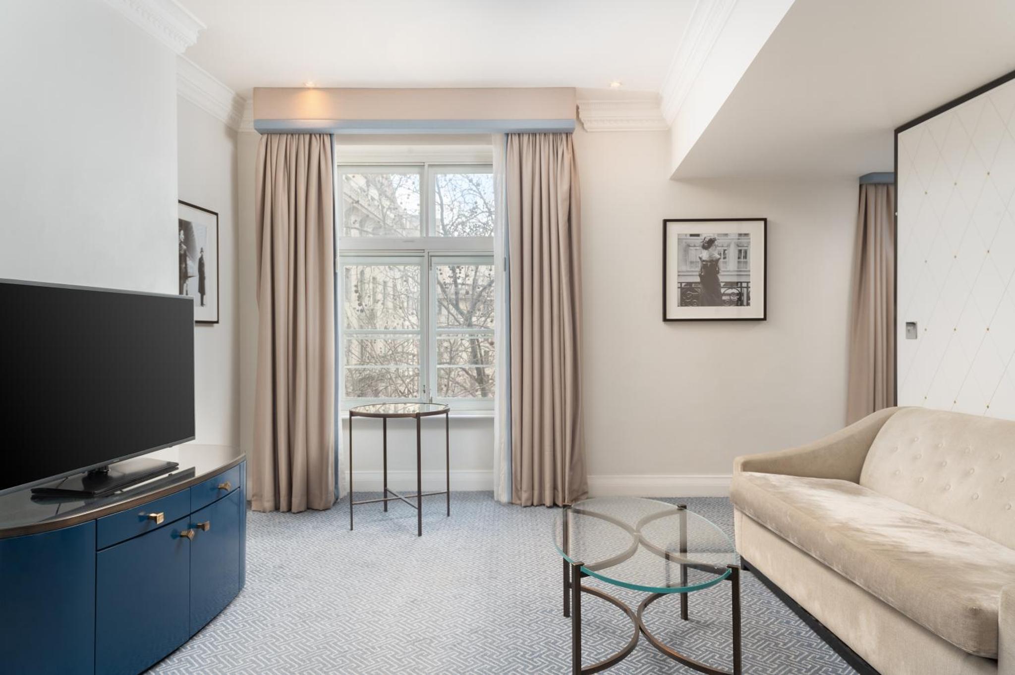 a living room with a couch and a tv at The Waldorf Hilton in London