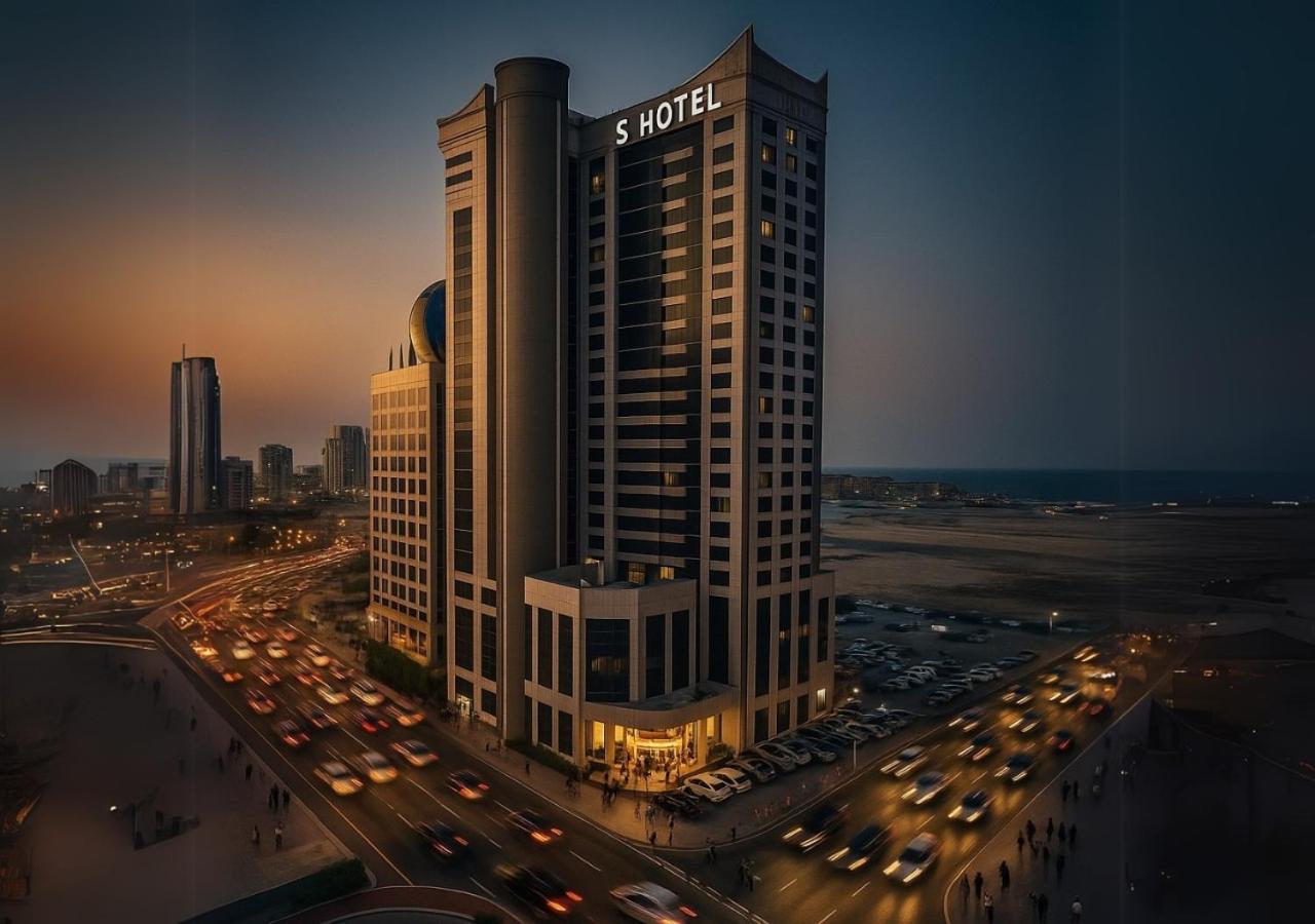 a tall building with a sign on top of it at S Hotel Bahrain in Manama