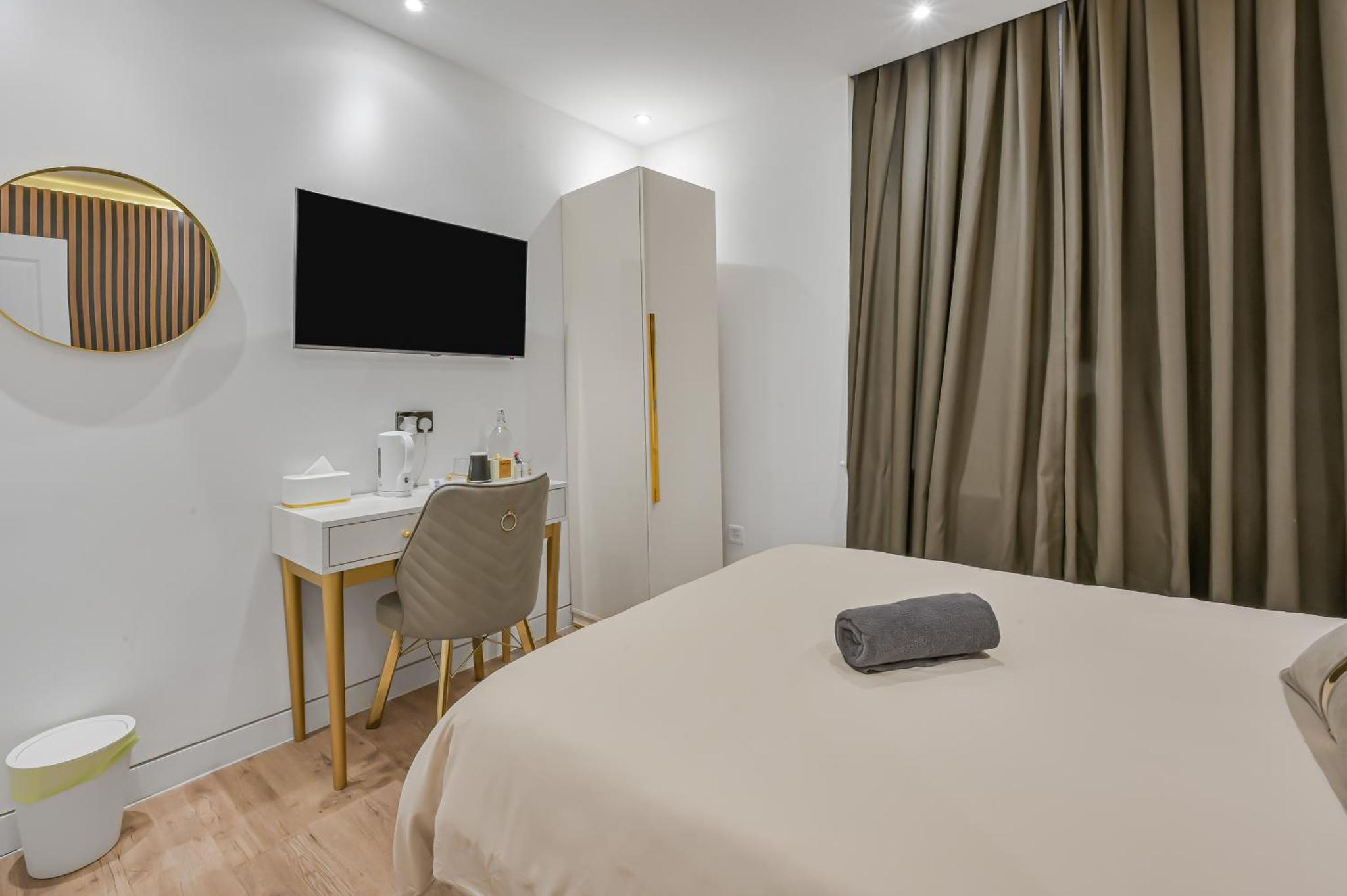 a hotel room with a bed and a desk and a television at Studio 64 in London +29 photos