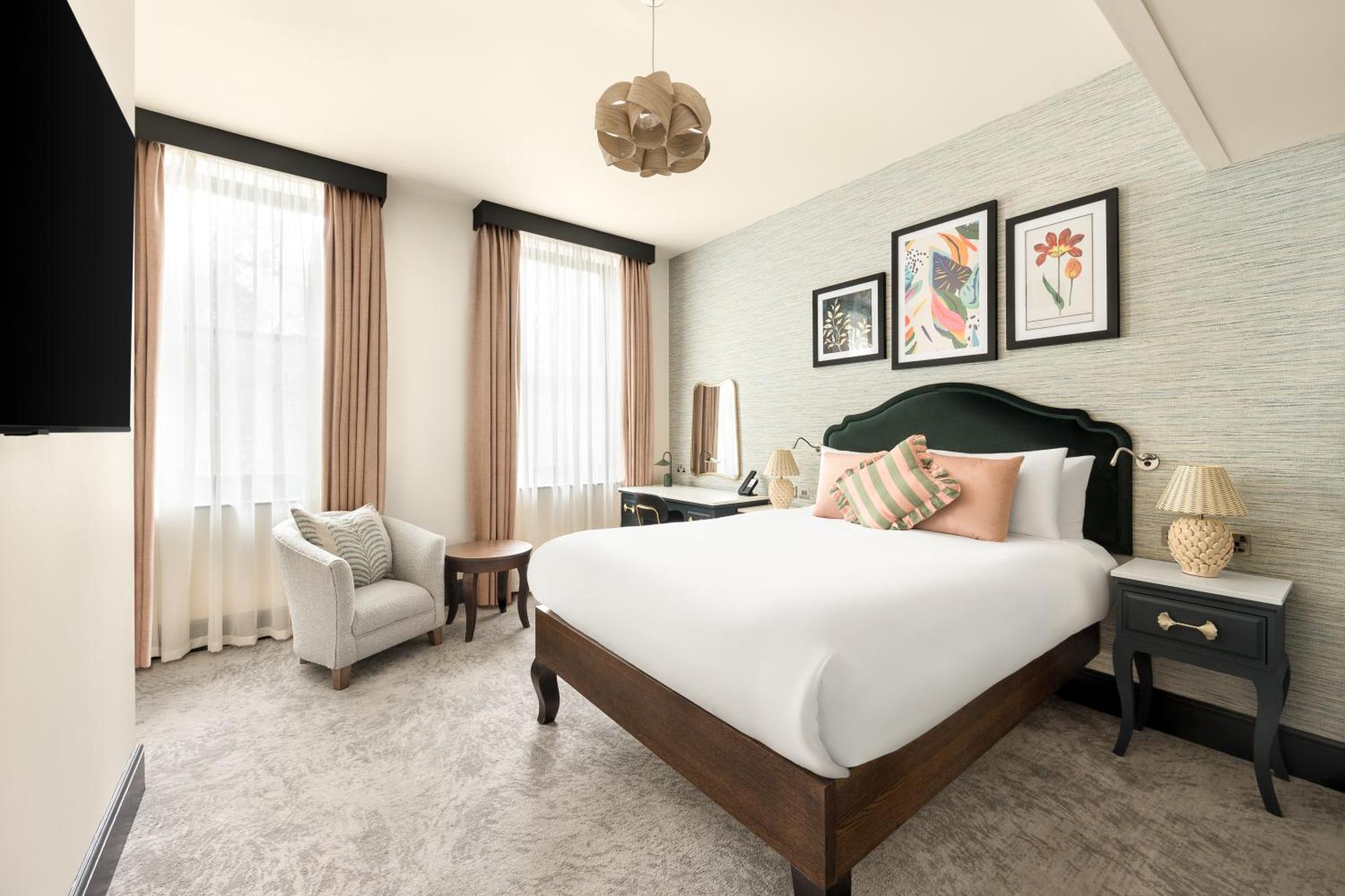 a hotel room with a bed and a chair at Hotel Indigo London - Kensington by IHG in London