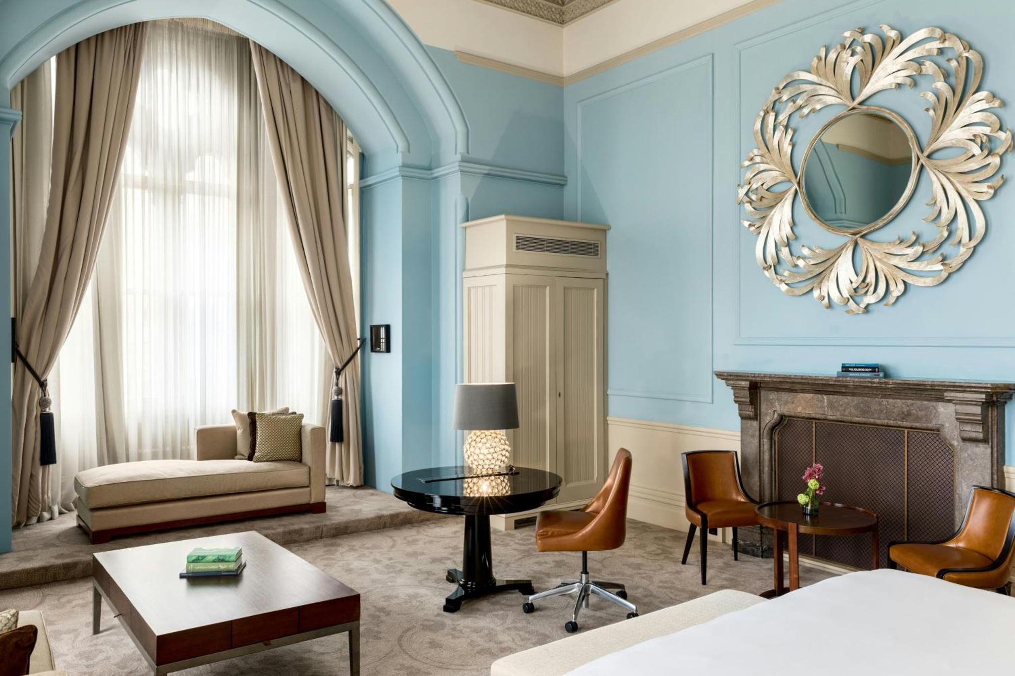 a living room with blue walls and a fireplace at St Pancras London, Autograph Collection in London
