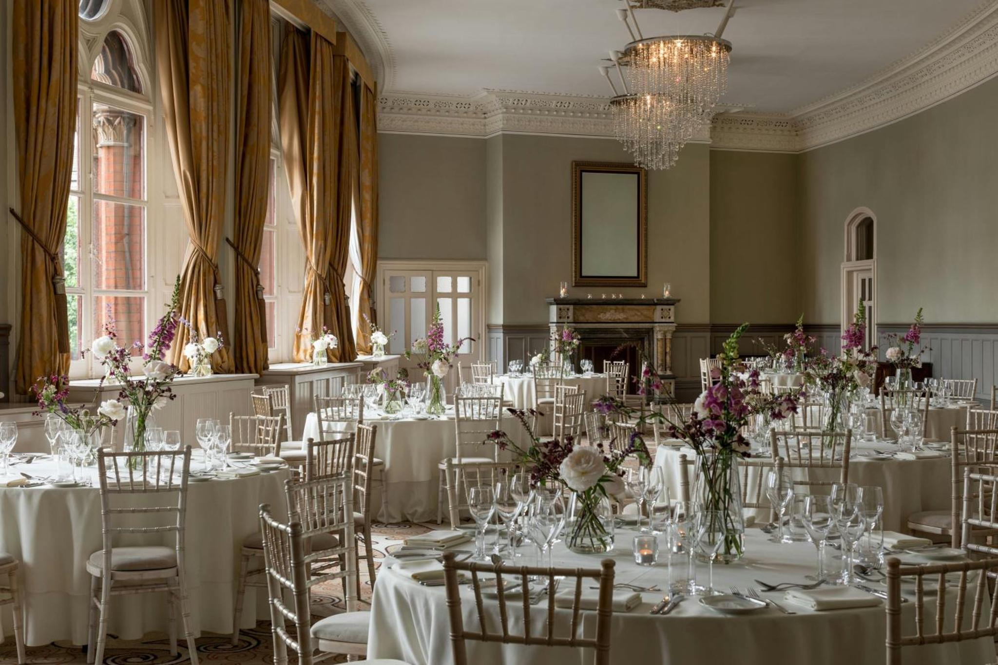 a room filled with tables and chairs with flowers at St Pancras London, Autograph Collection in London +147 photos