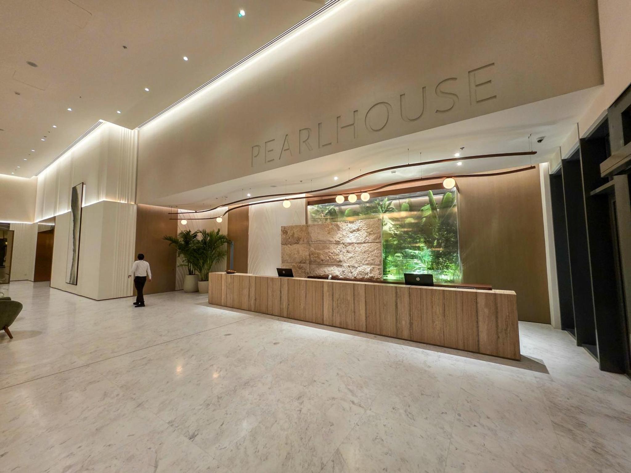 a woman standing in a lobby of a building at Pearlhouse Bahrain Brand New 1BR with Balcony in Manama +21 photos
