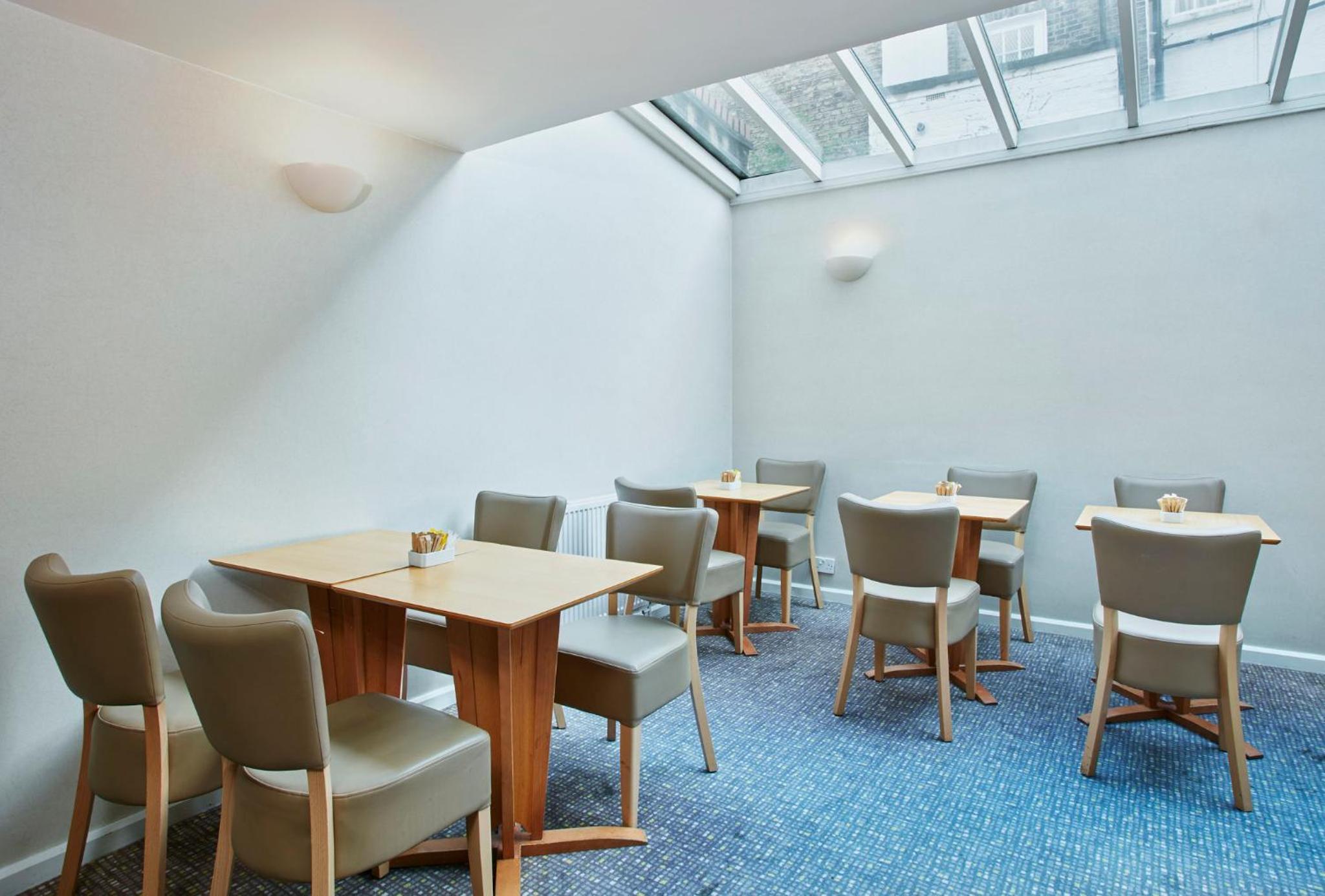 a room with tables and chairs and a skylight at Holiday Inn Express London Victoria by IHG in London