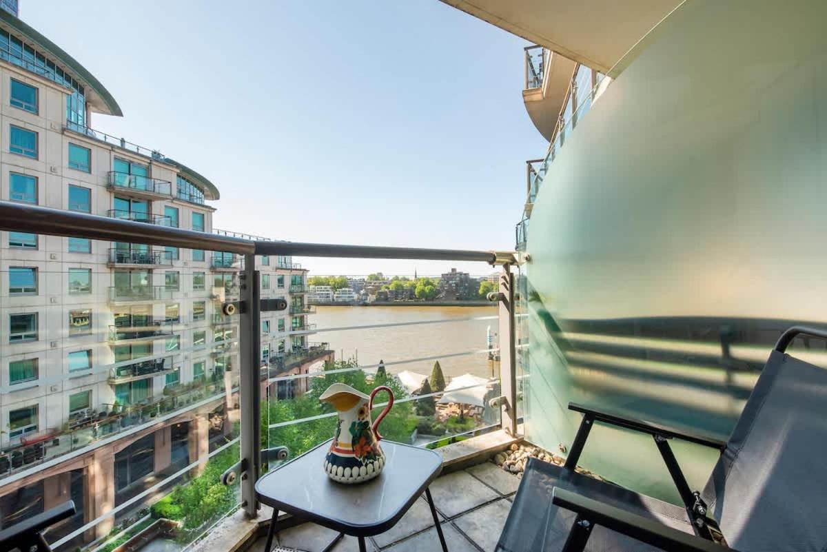a balcony with a table and a view of a river at Charming 2 bed Thames view in London