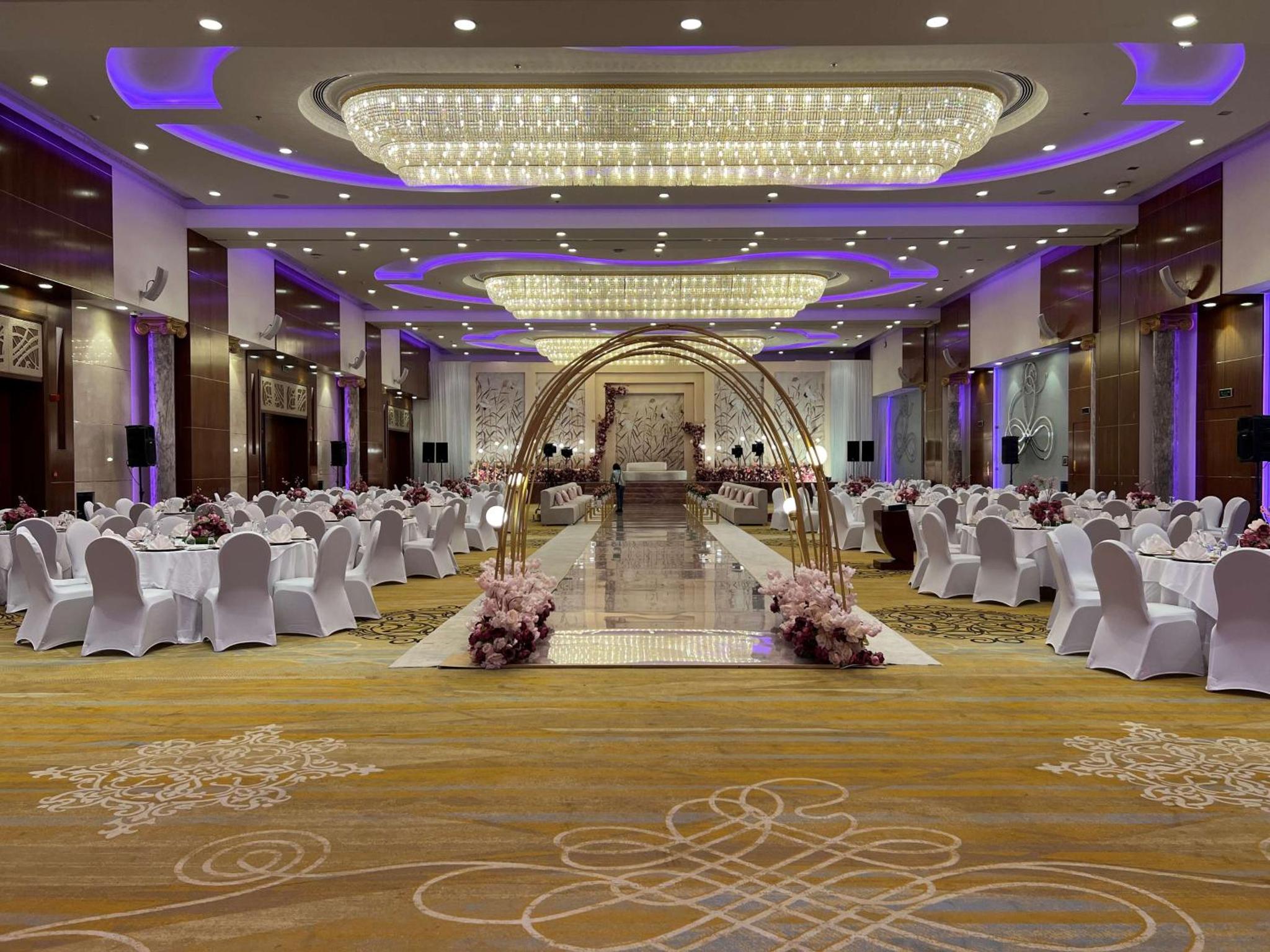 a banquet hall with white chairs and a dance floor at The Diplomat Radisson Blu Hotel Residence & Spa in Manama +217 photos