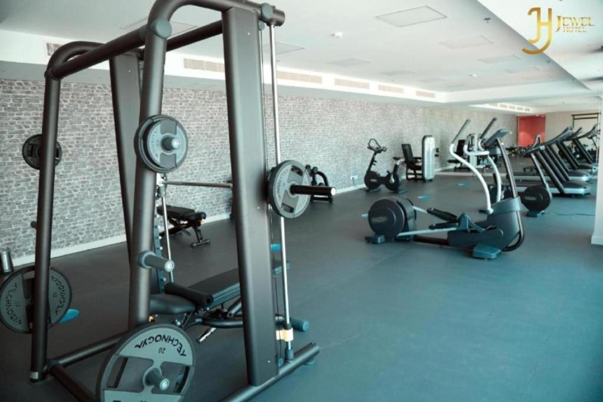a gym with several treadmills and cardio machines at Bellvila Luxury Downtown Adliya Formerly Jewel Hotel in Manama
