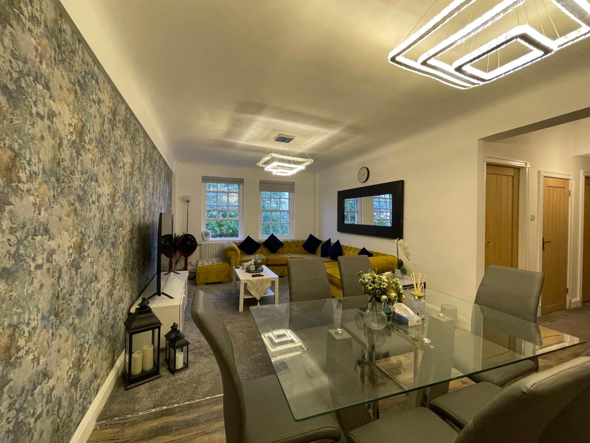 a living room with a glass table and a couch at Kensington Apartment in London