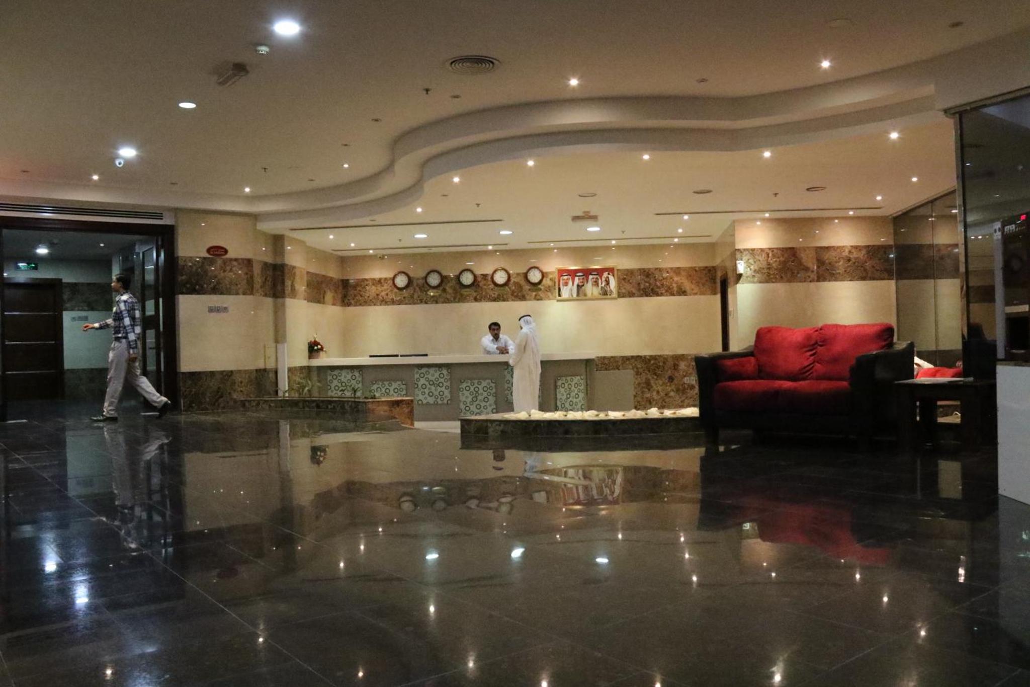 a lobby with a red couch and a red chair at Marina Tower in Juffair +31 photos