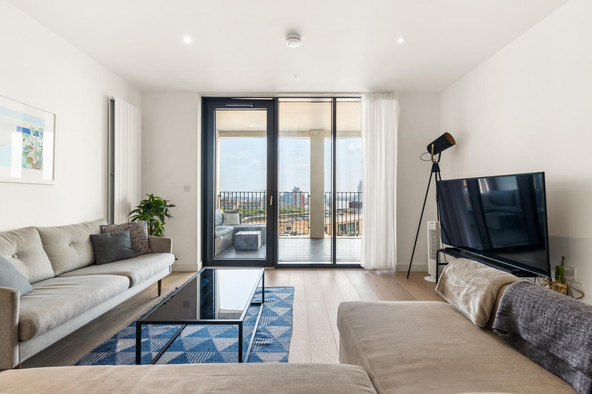 a living room with a couch and a tv at Spacious modern 1 bed Apartment. in London