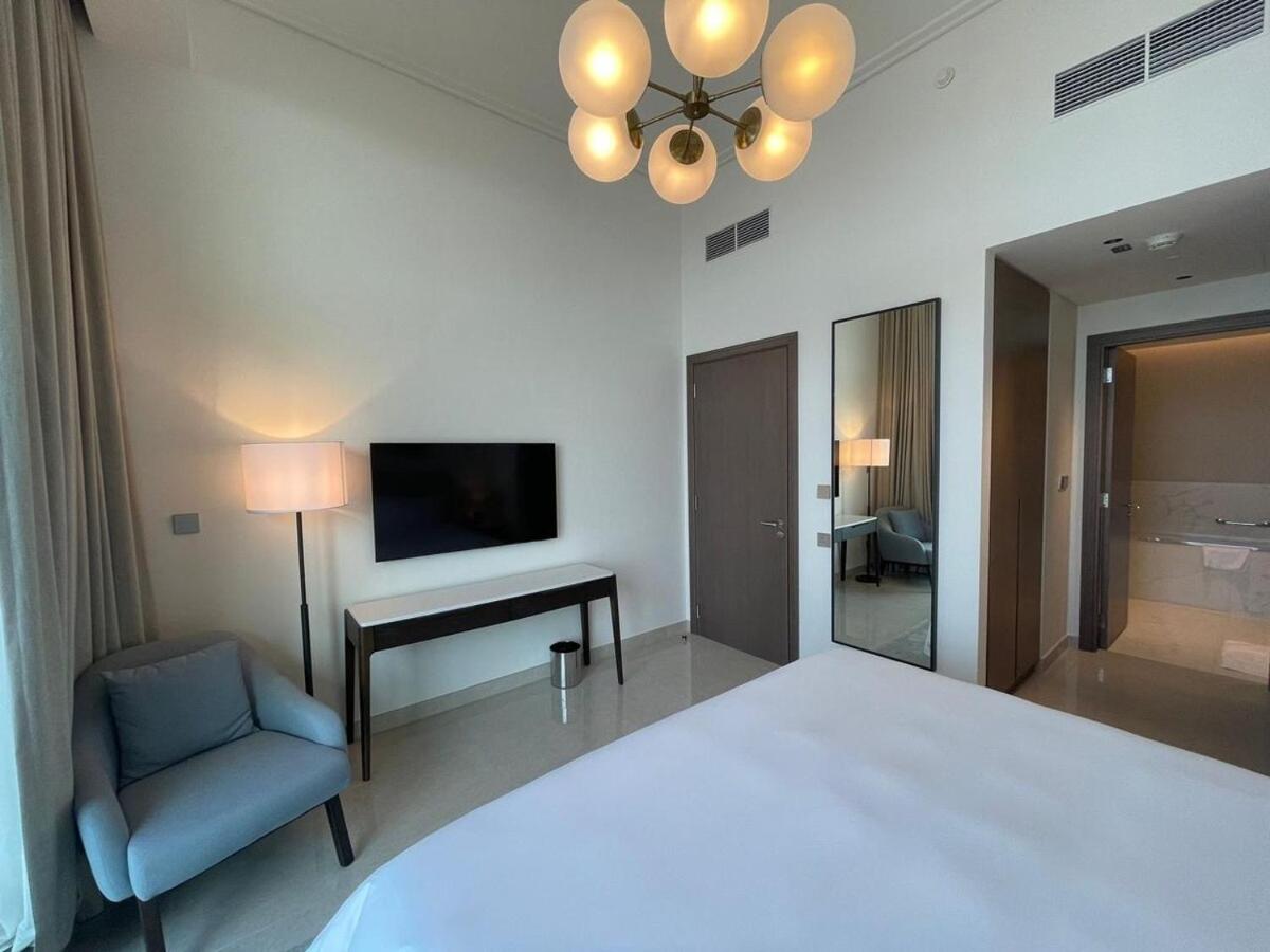 a bedroom with a bed and a chair and a desk at Address Residences Beach Resort Bahrain in Rayyā +31 photos