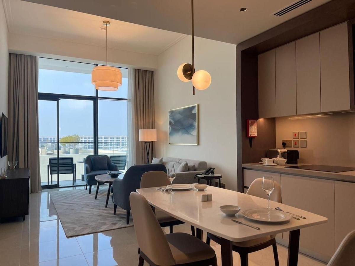 a kitchen and a living room with a table and chairs at Address Residences Beach Resort Bahrain in Rayyā