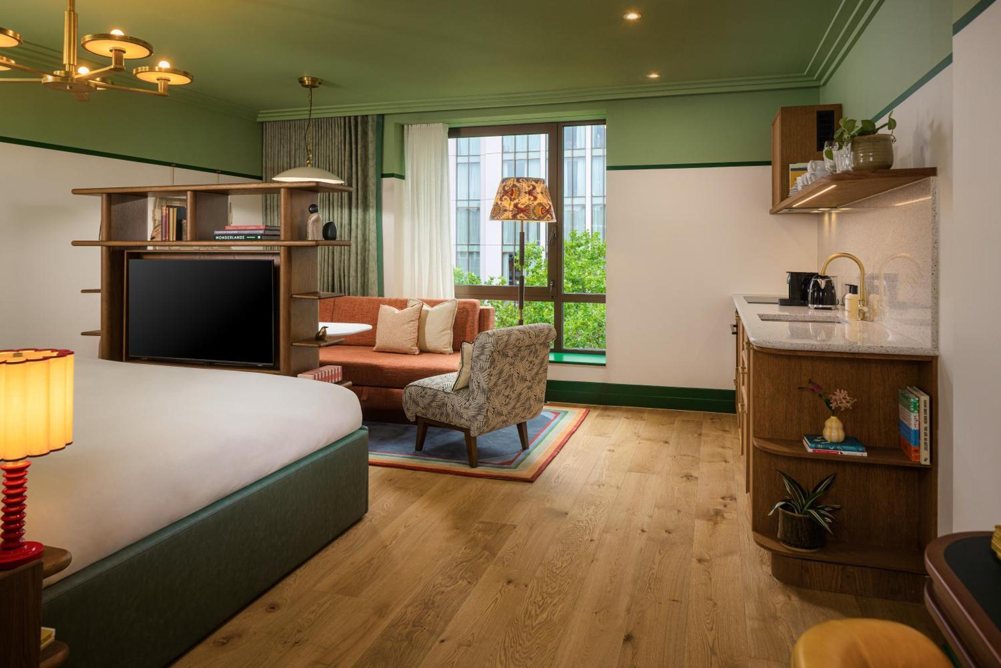 a bedroom with a bed and a living room at The July - London Victoria in London
