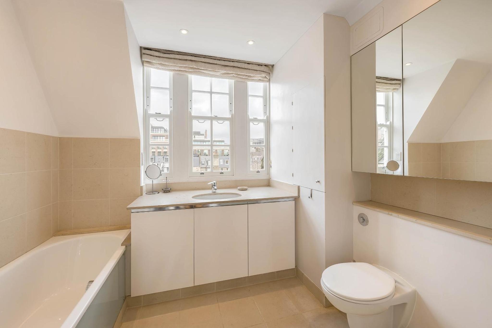 a bathroom with a toilet and a sink and a bath tub at Top view Notting Hill Kensington in London